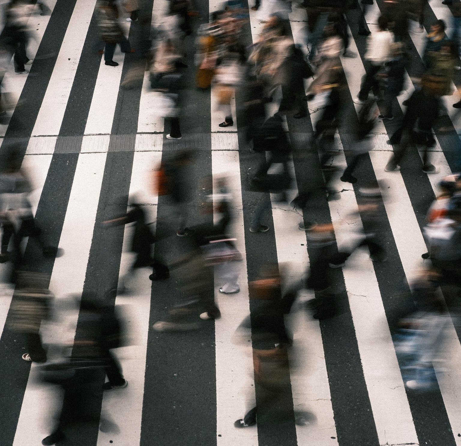 Busy intersection with people crossing a pedestrian walkway