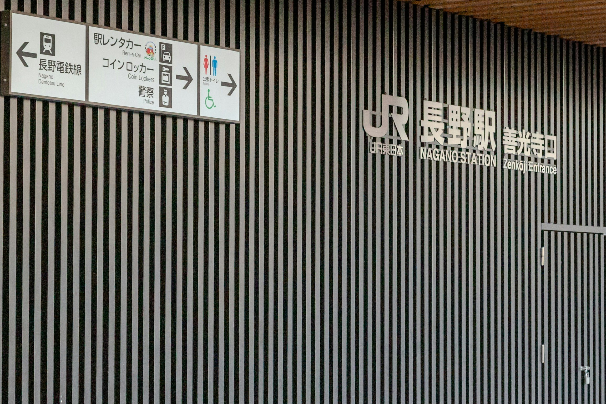 長野駅の駅舎外壁に掲げられた案内標識とロゴ