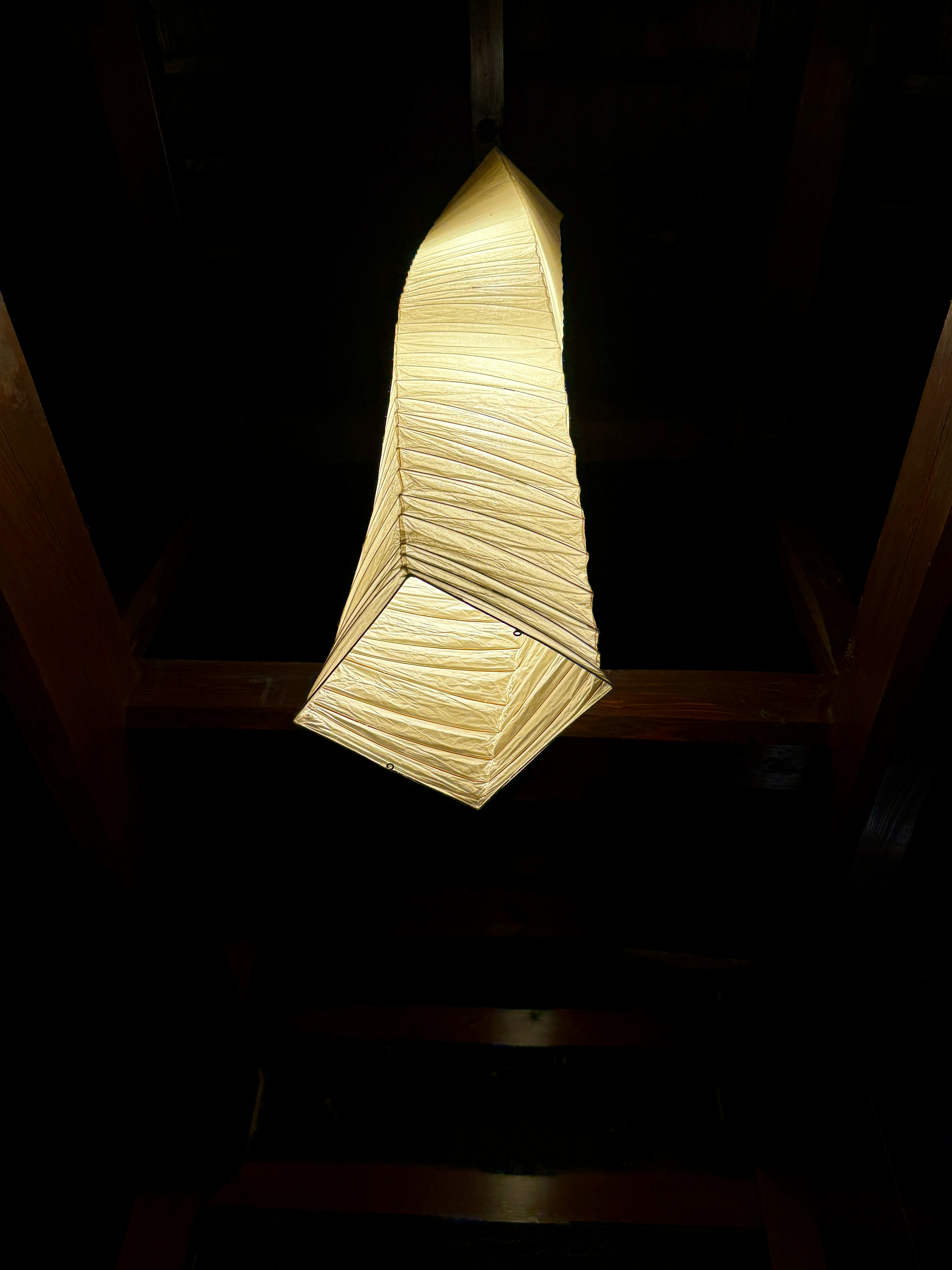 Suspension d'un luminaire de forme unique sur un fond sombre