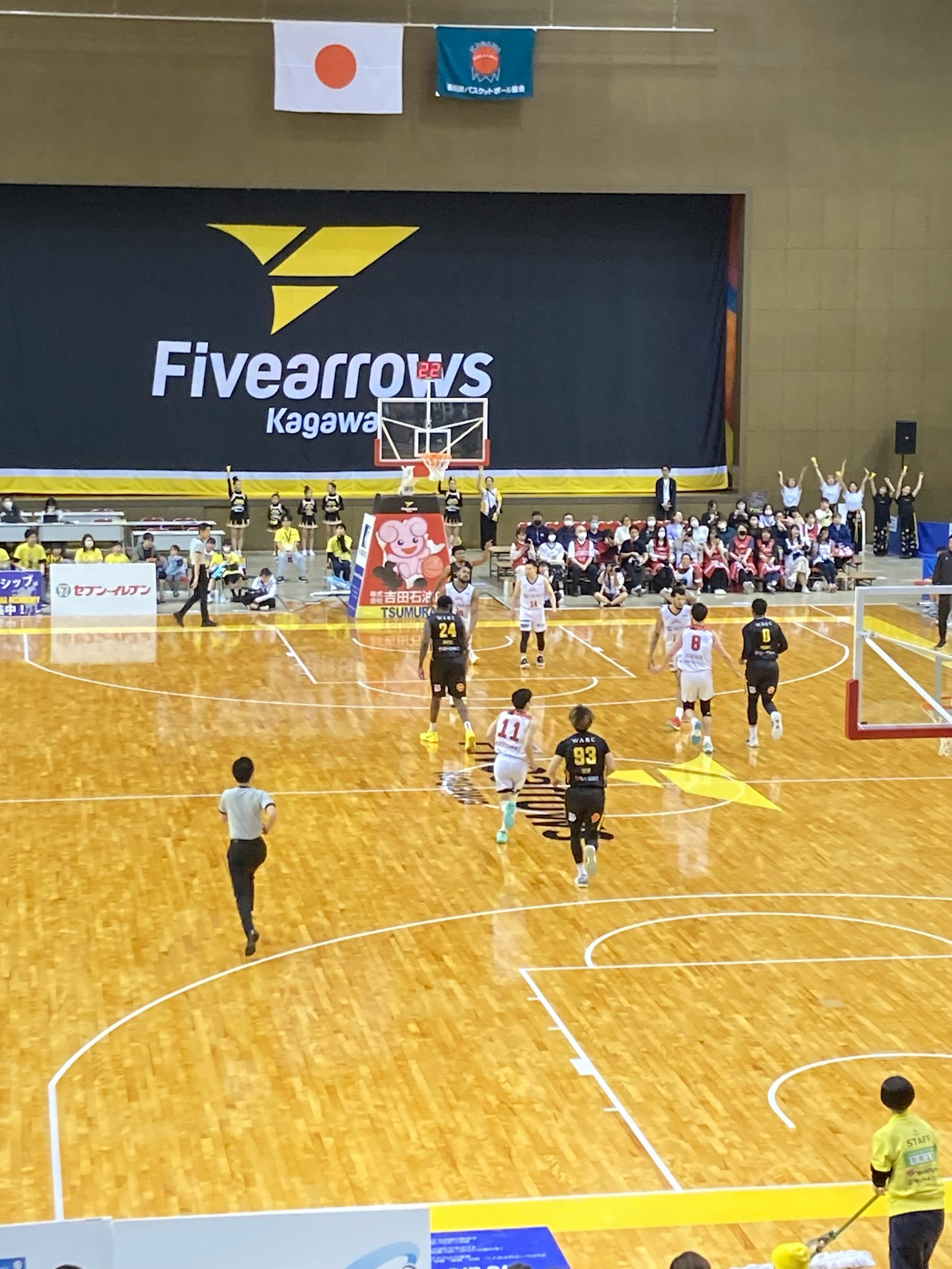 Partido de baloncesto con jugadores y espectadores en un gimnasio