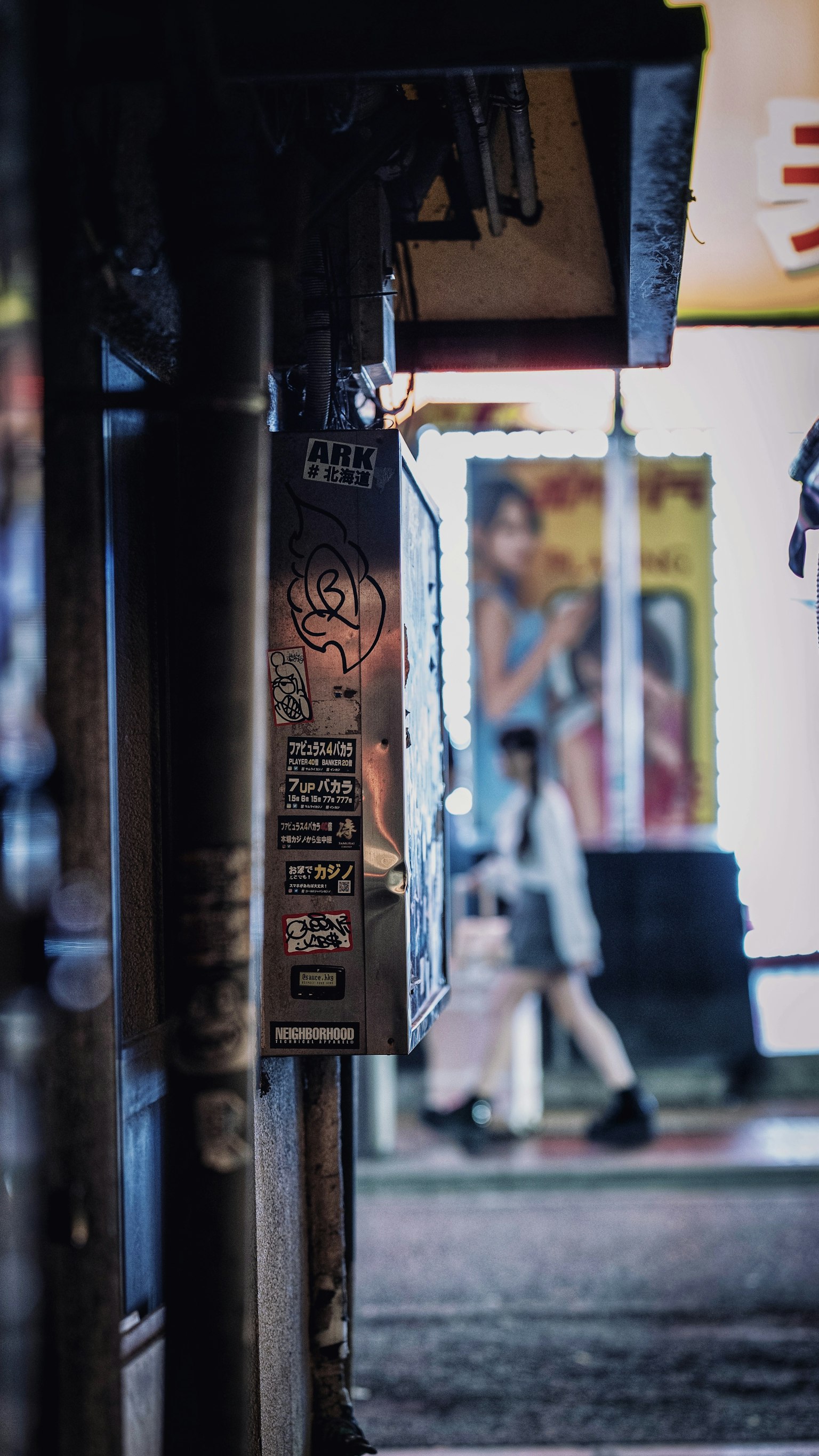 Un letrero en un callejón oscuro con una persona caminando por la calle