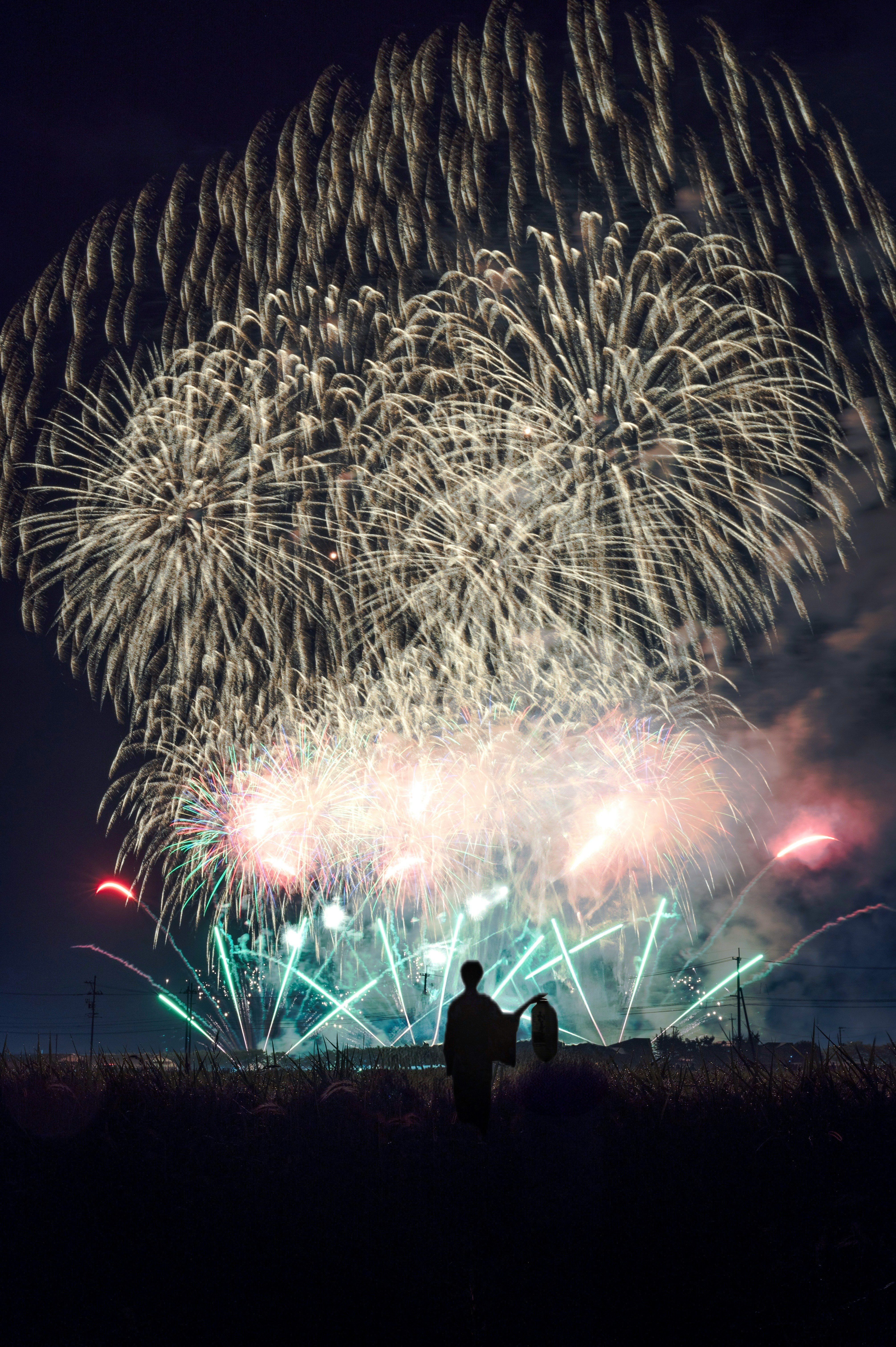 大曲がり花火大会の夜空に広がる大輪の花火と観客のシルエット