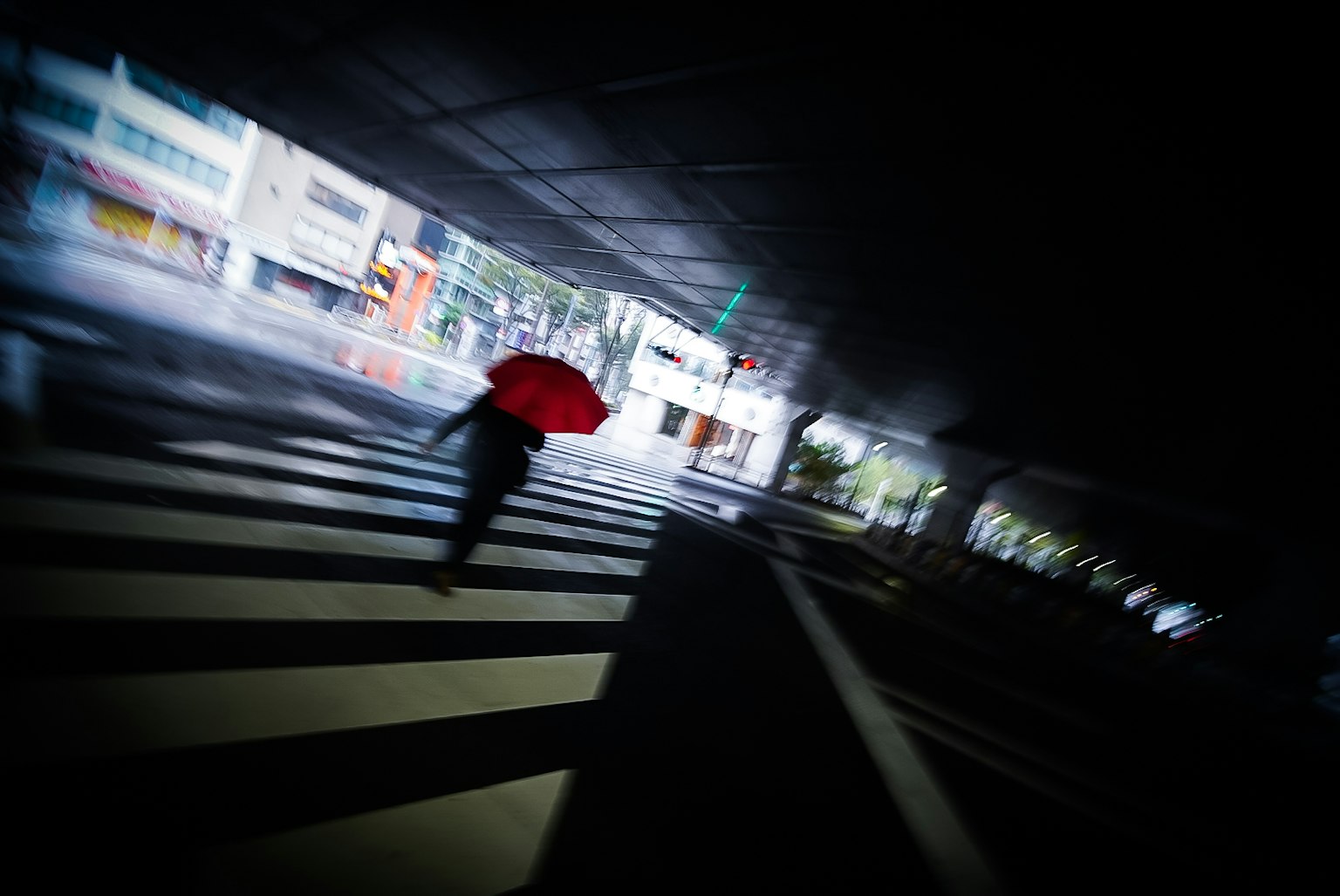 Silhouette seseorang menyeberang jalan dengan payung merah