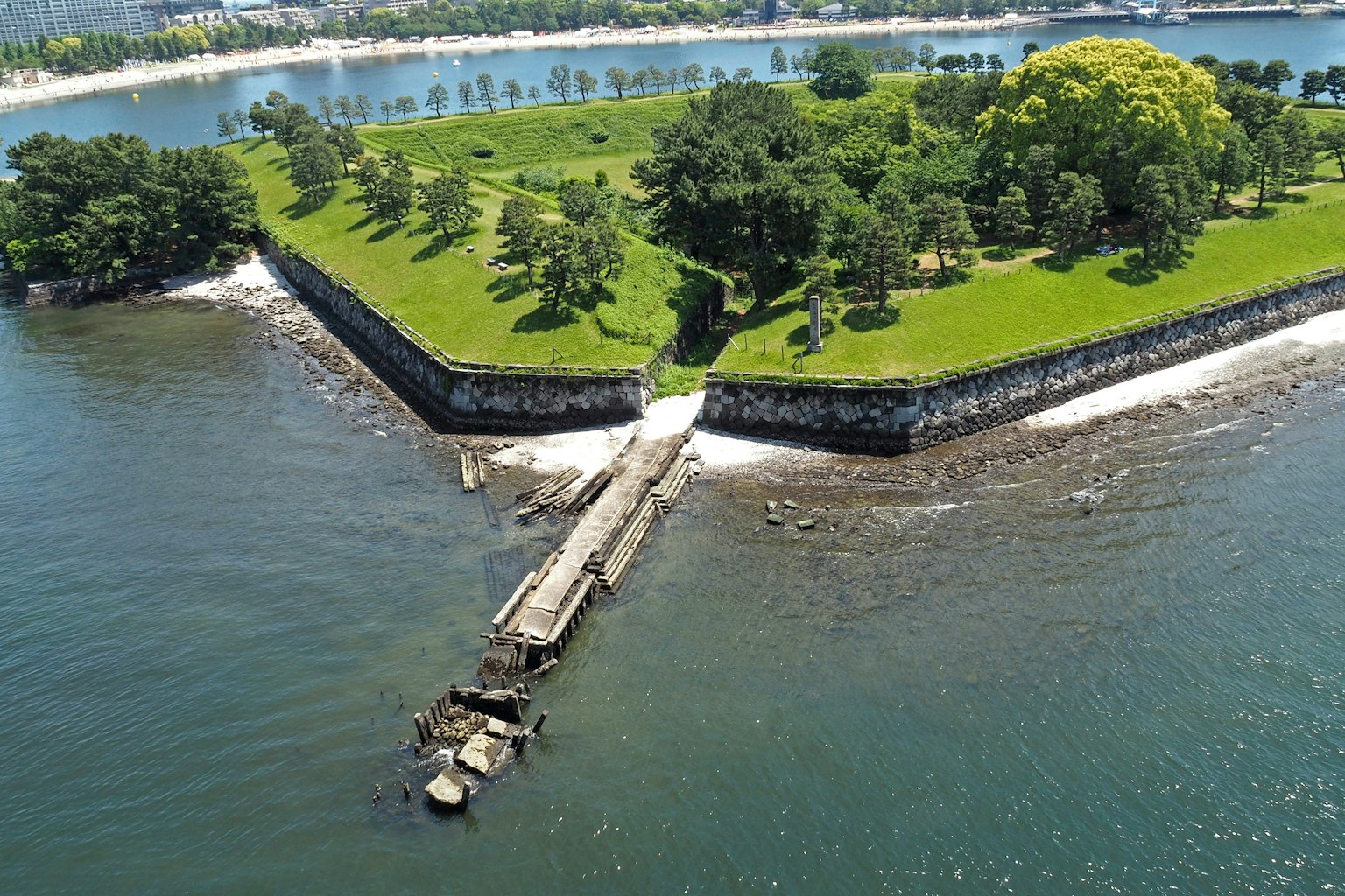 Vue aérienne d'une île verte entourée d'arbres un pont s'étendant dans l'eau