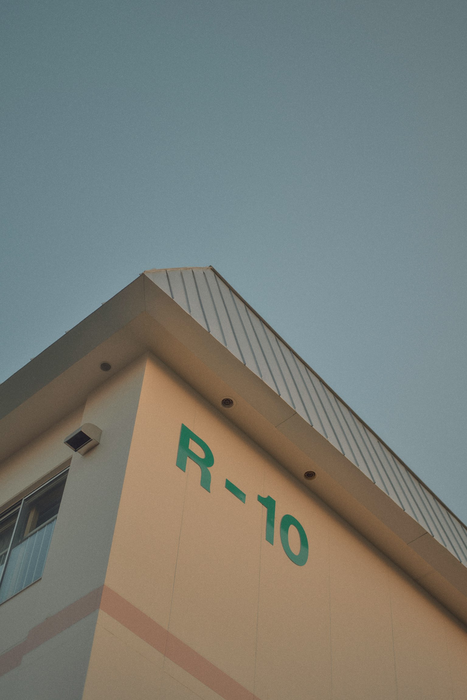 建筑角落的绿色R-10标志和晴朗的天空