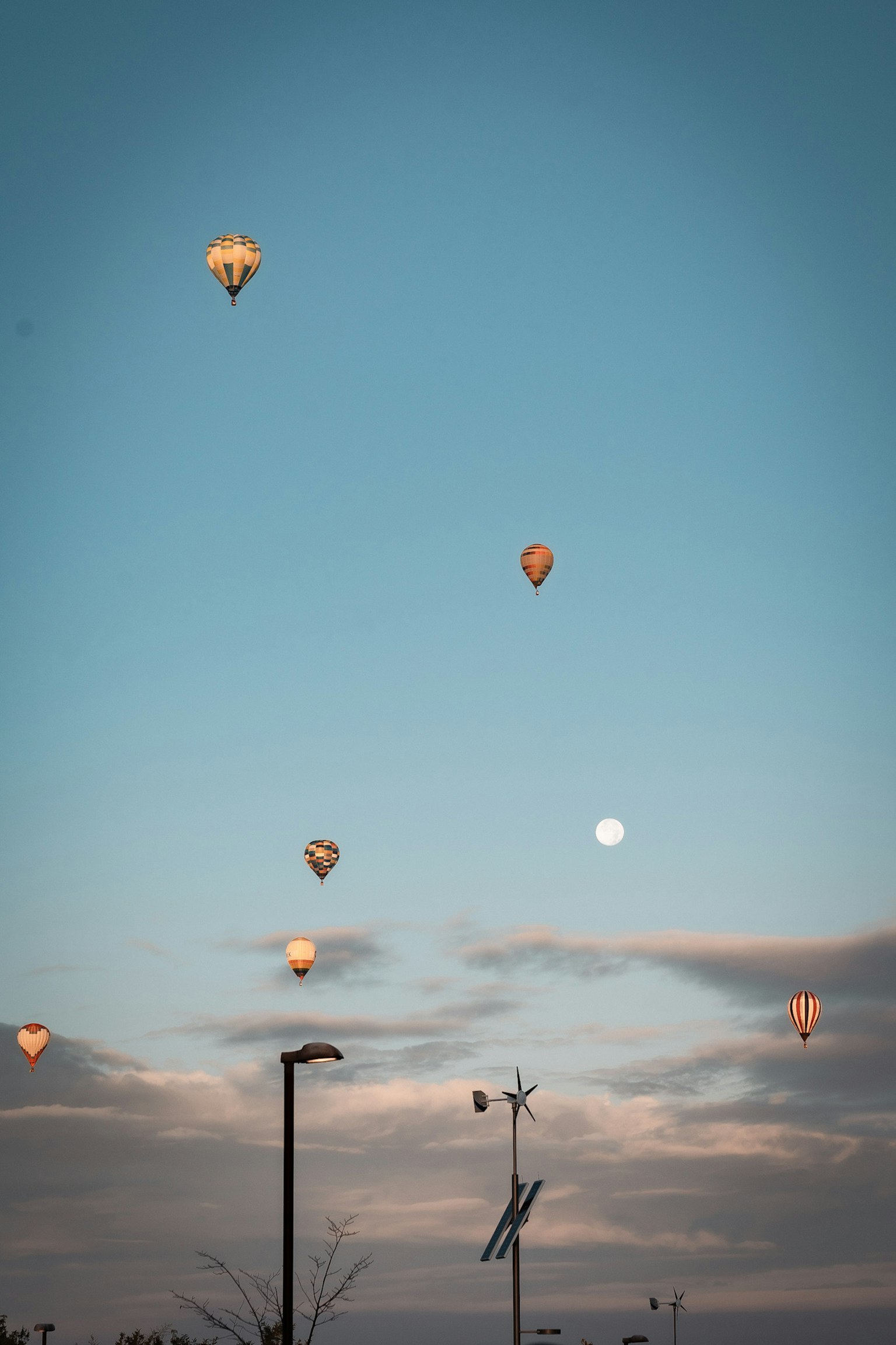 Bunte Heißluftballons im blauen Himmel mit einem hellen Mond
