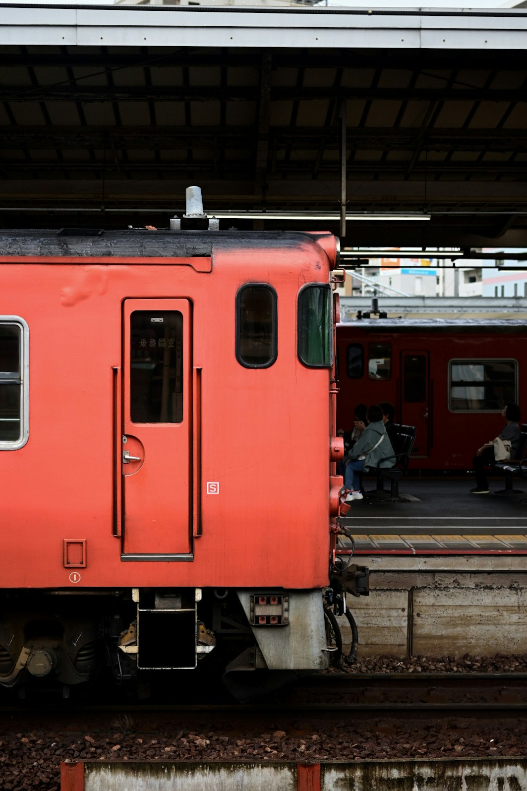 赤い車両が並ぶ鉄道のホーム