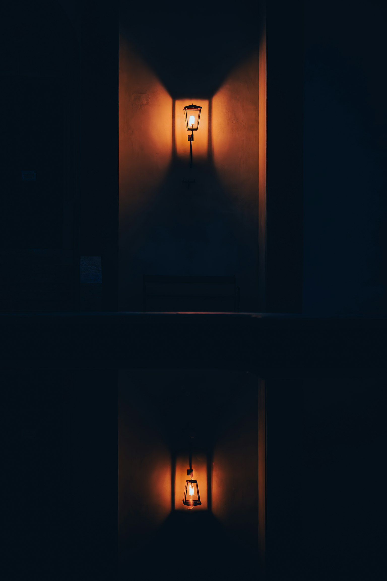 Lampada da parete che emette una luce arancione calda su uno sfondo scuro