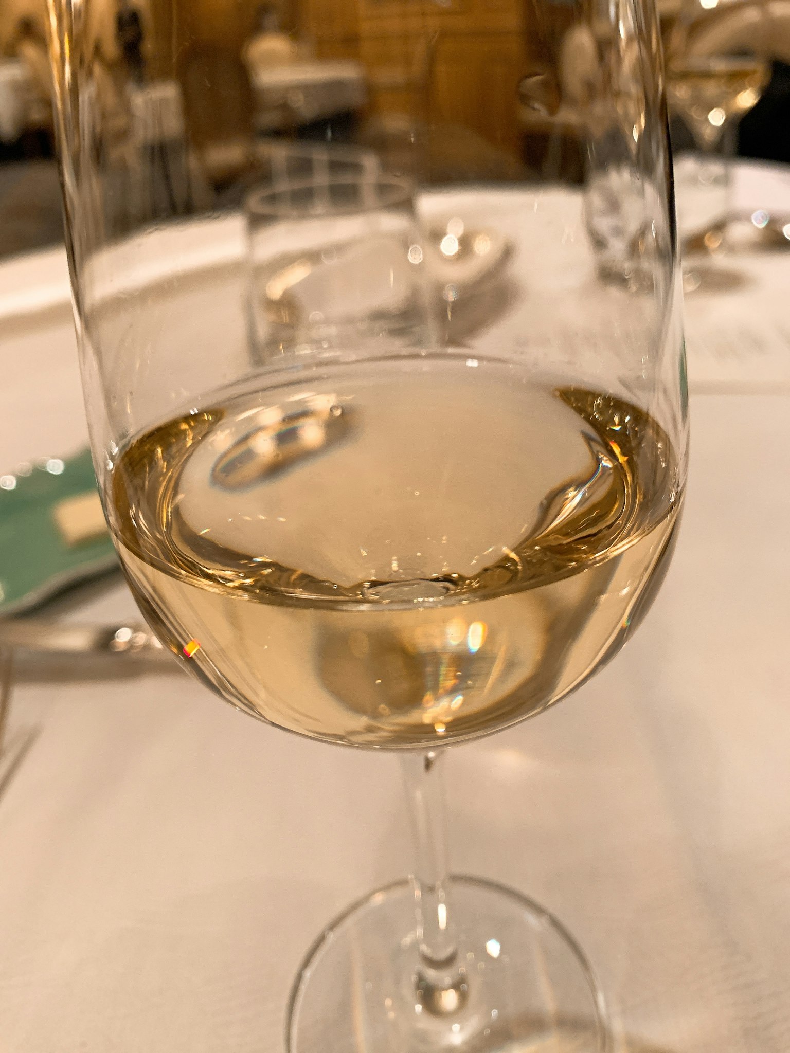 Una copa de vino blanco en una mesa