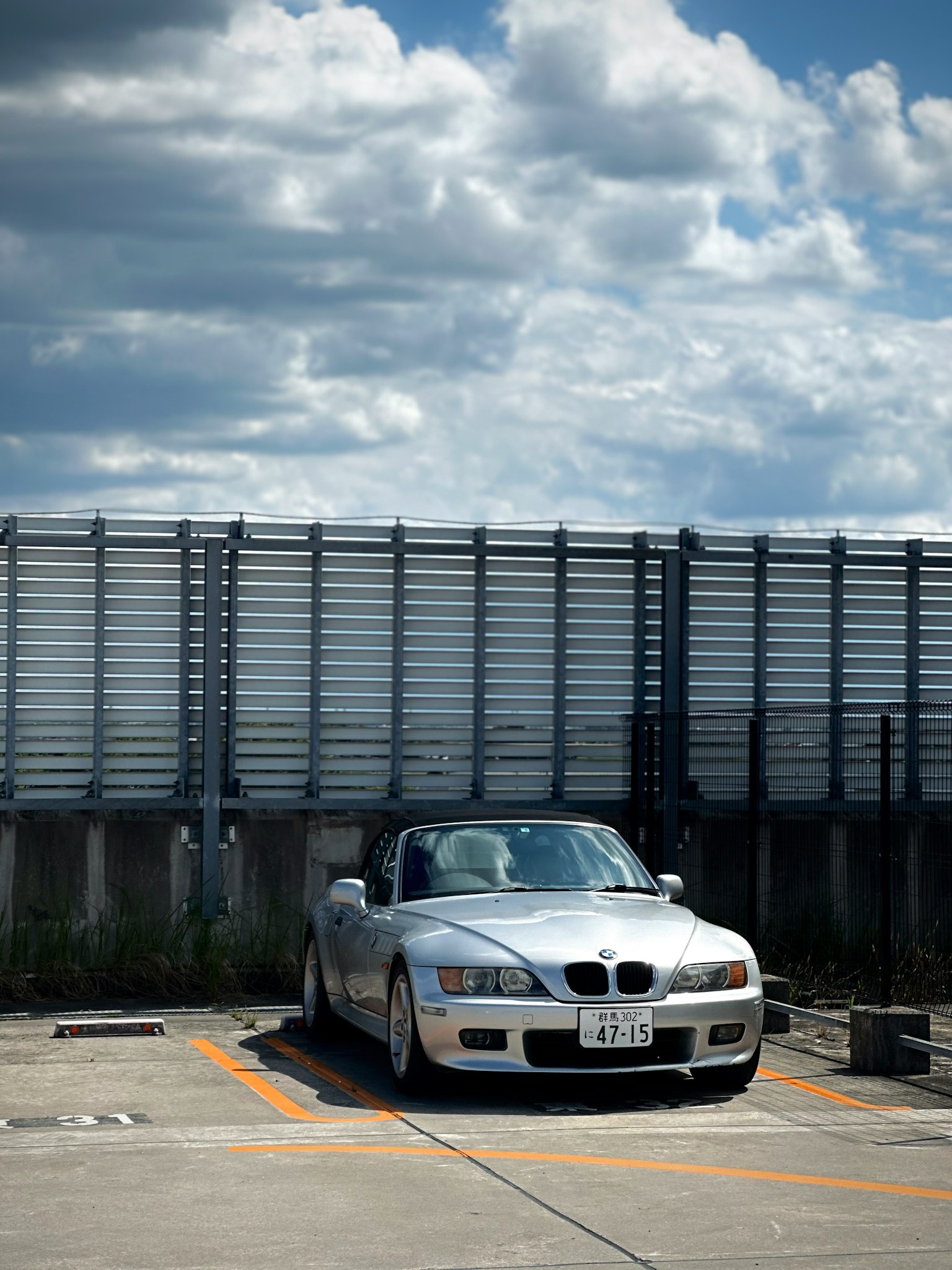 구름이 많은 하늘을 배경으로 주차된 흰색 BMW 컨버터블