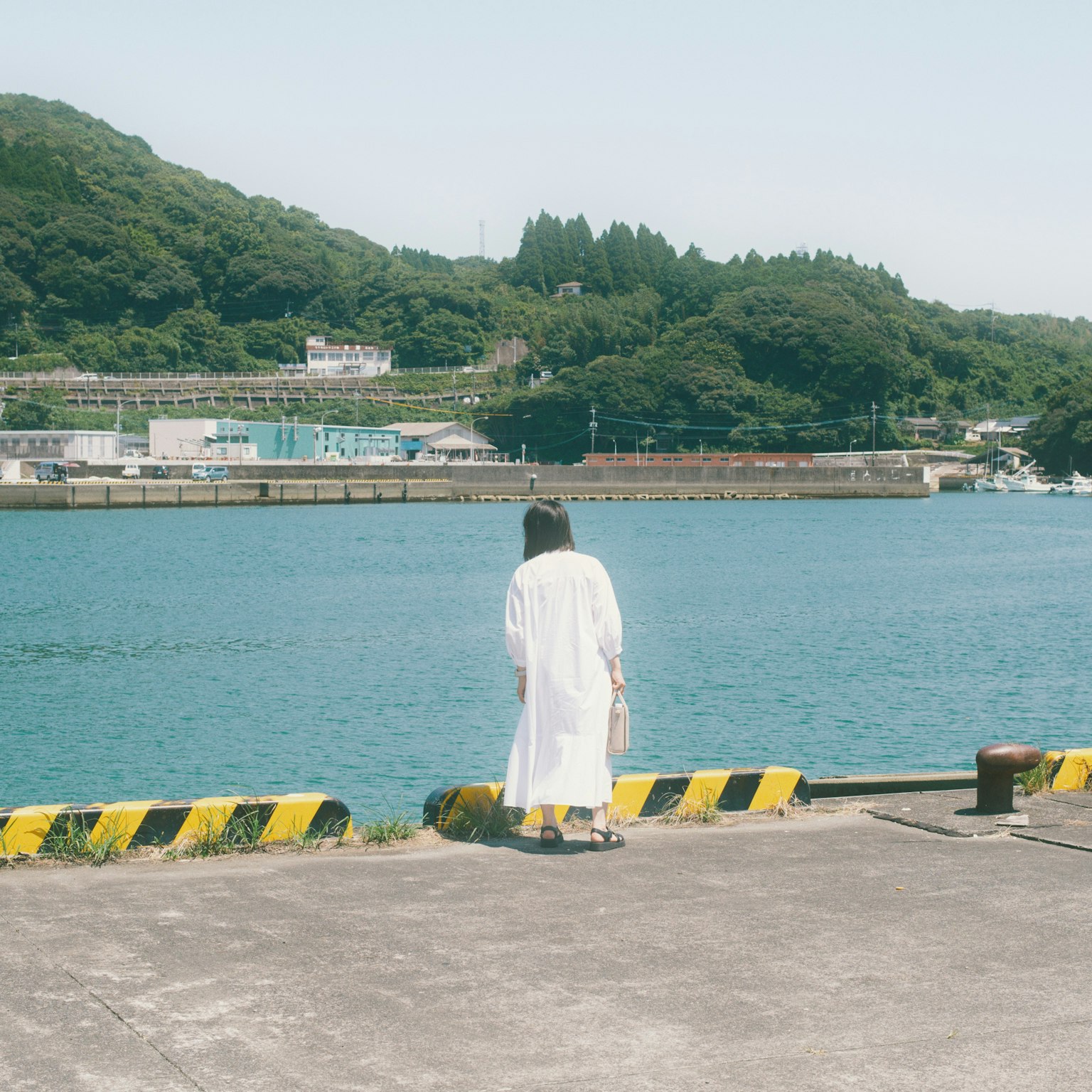 A woman in a white dress gazing at the sea