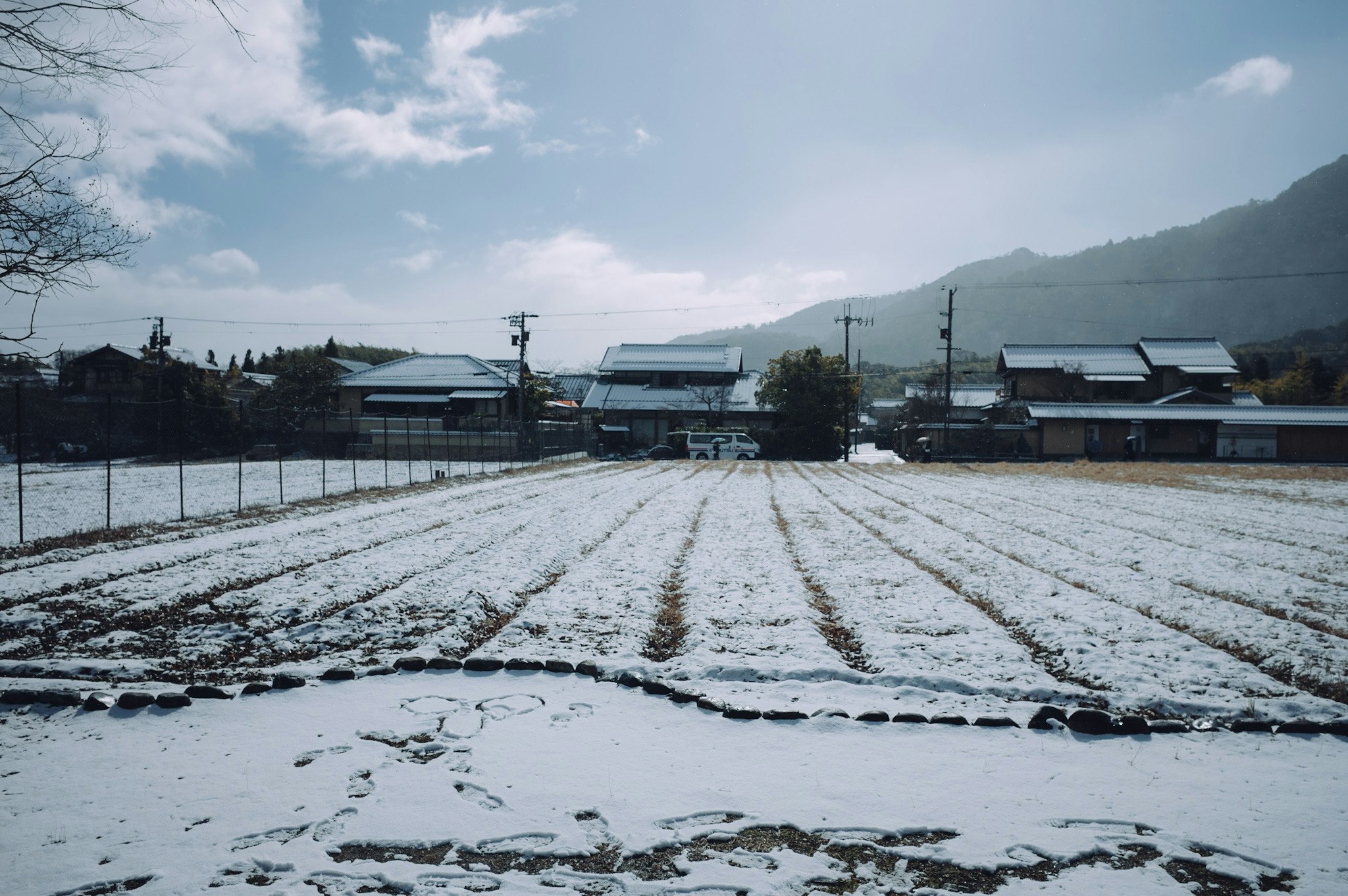 snow-covered fields with a village of houses in the distance