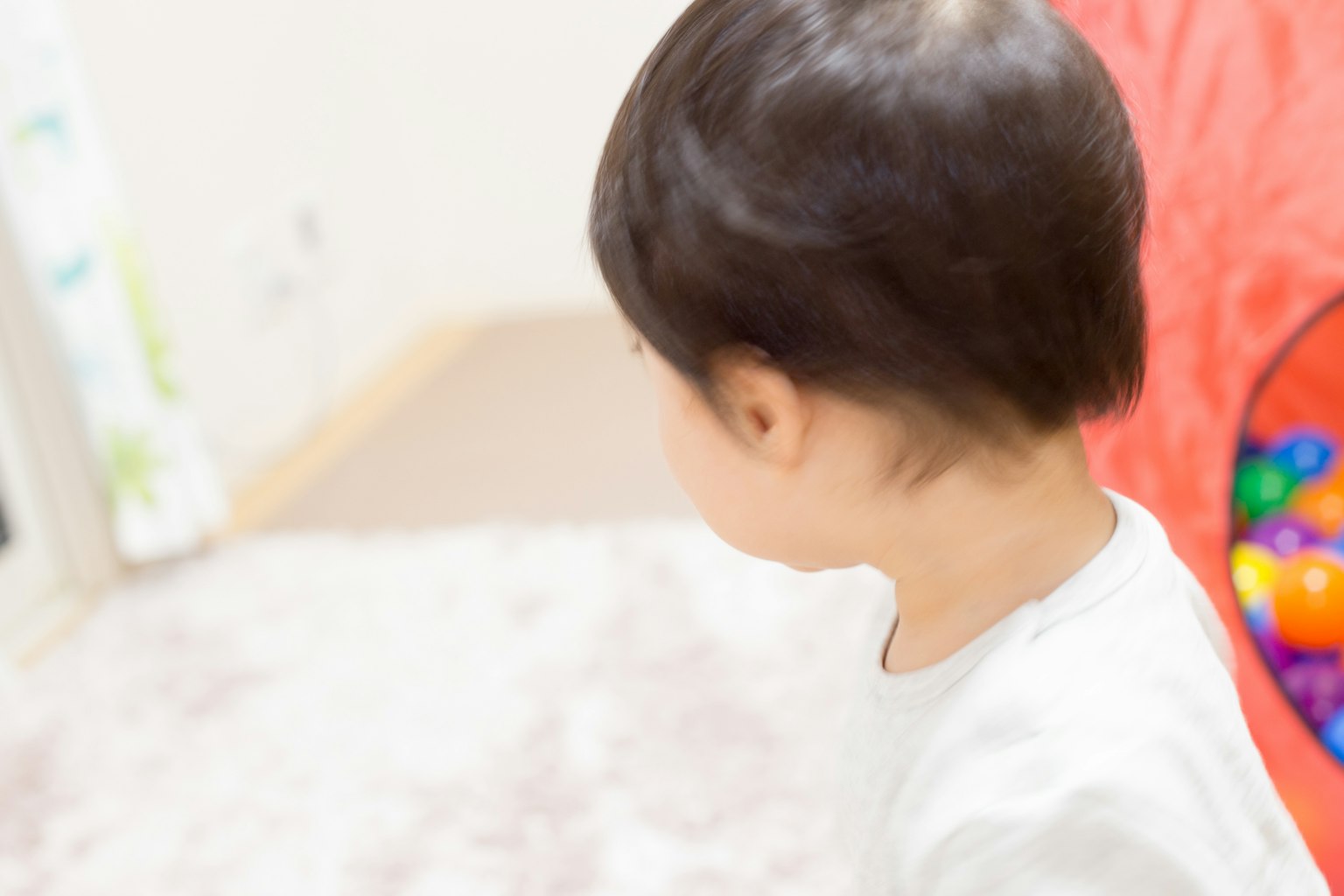เด็กหันหลังในห้องสว่างที่มีลูกบอลสีสัน