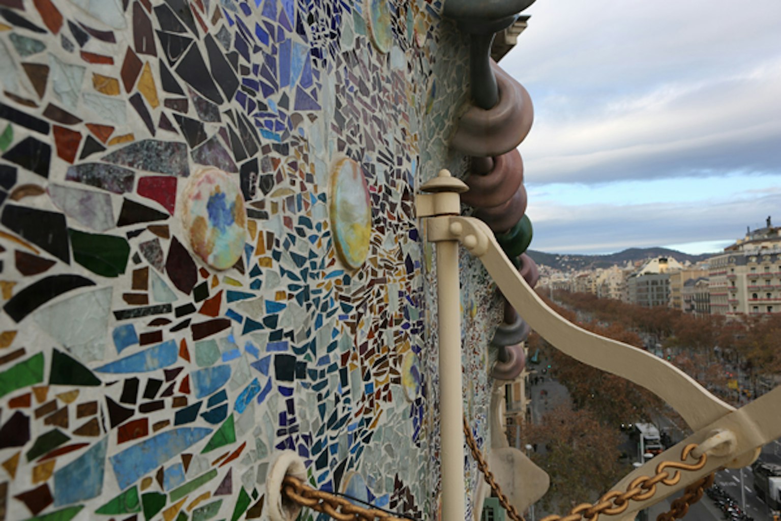 ภาพระยะใกล้ของผนังโมเสคที่ Casa Batlló ในบาร์เซโลนา พร้อมองค์ประกอบตกแต่ง