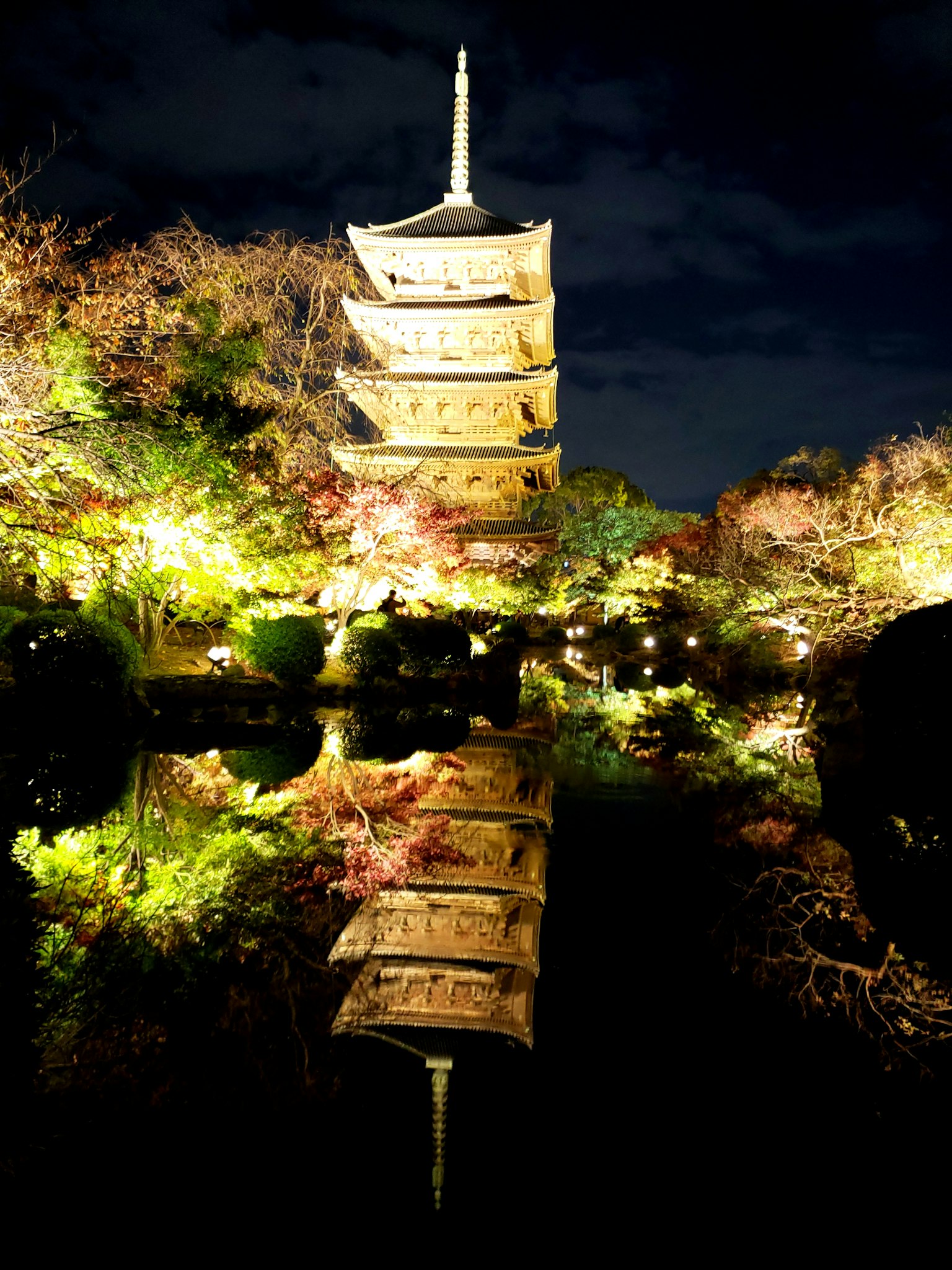 Hermosa vista de una pagoda de noche con reflejos en el agua