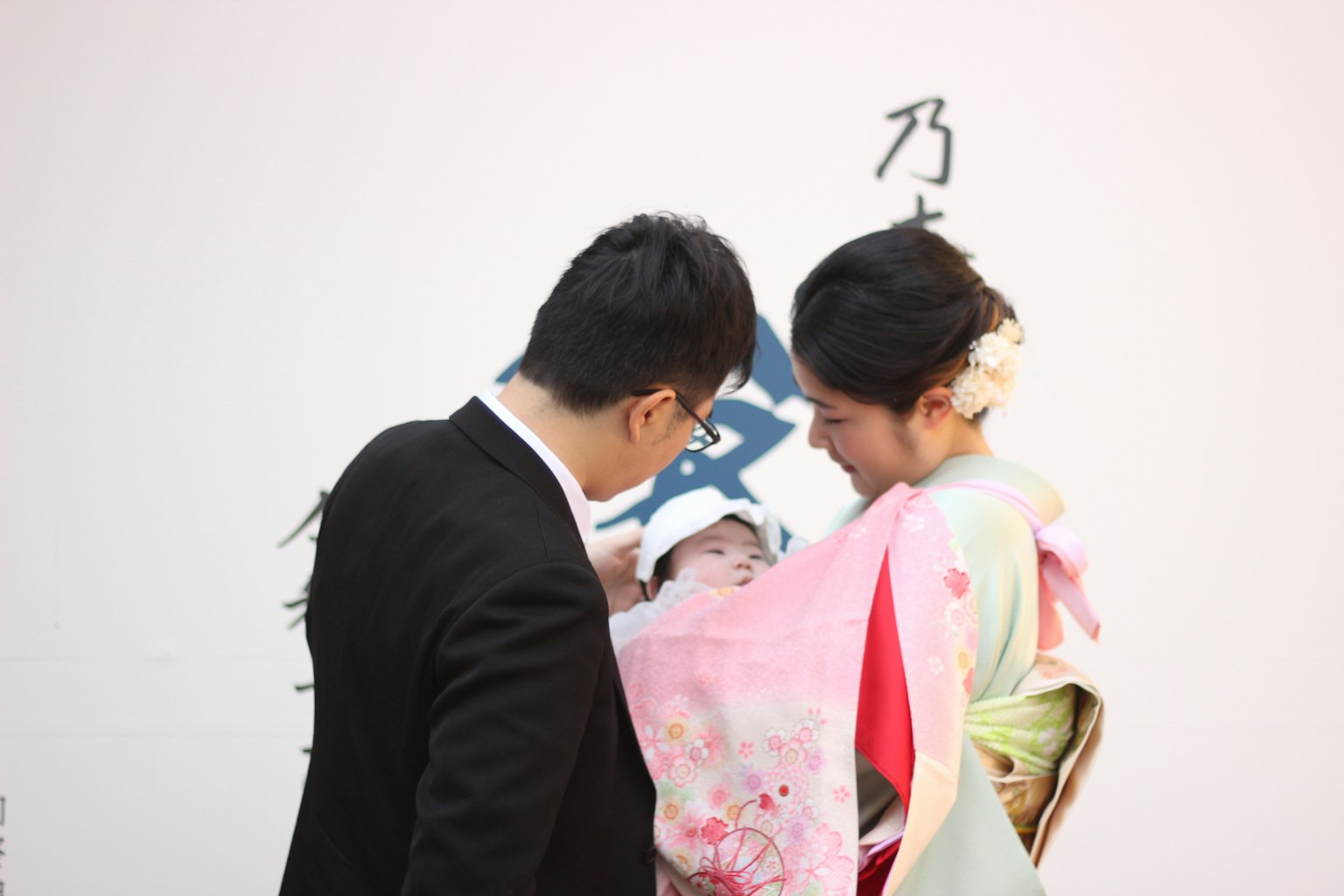 一家人正在庆祝，有一个婴儿和父母 母亲穿着美丽的和服
