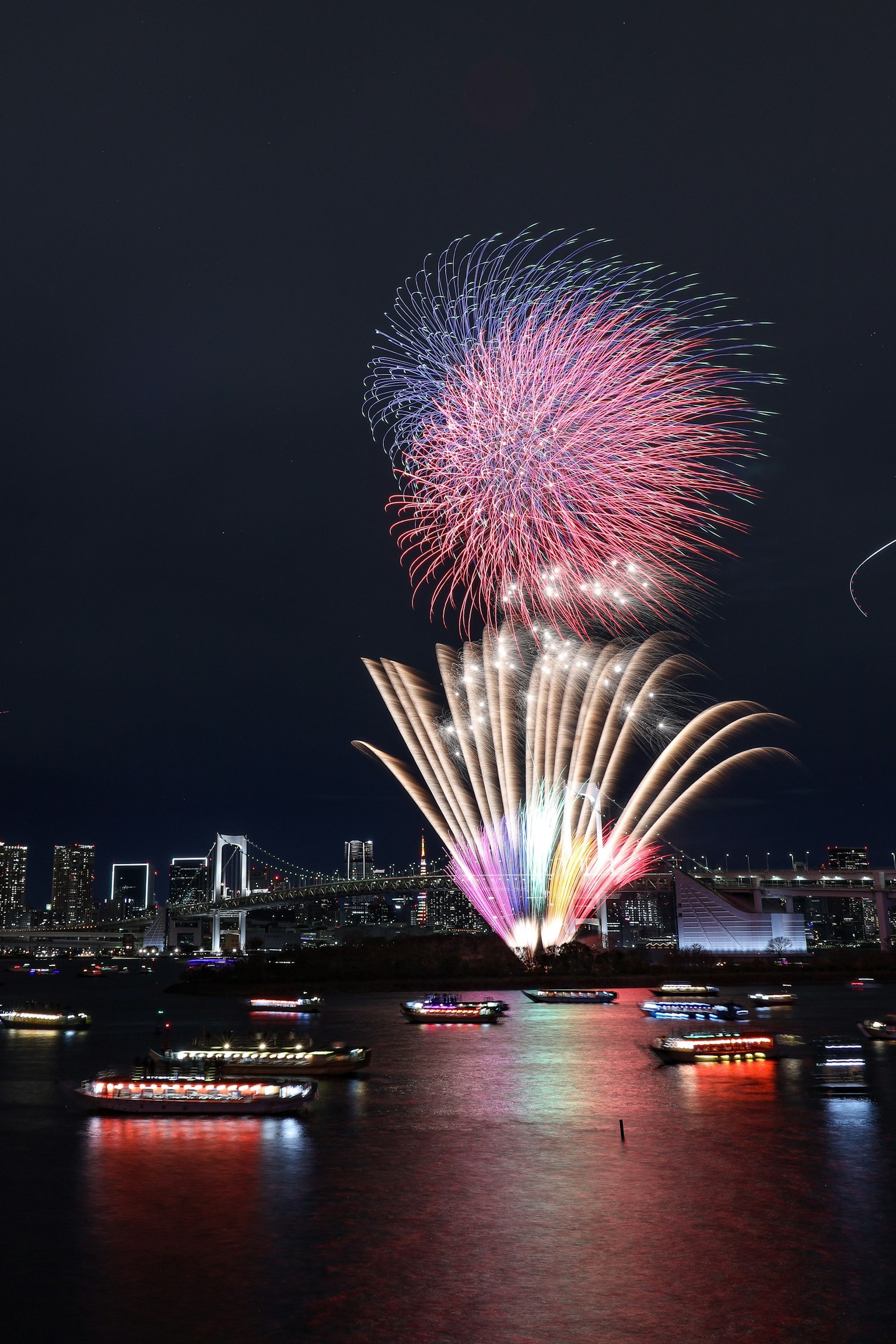 Colorful fireworks bursting in the night sky over Tokyo Bay