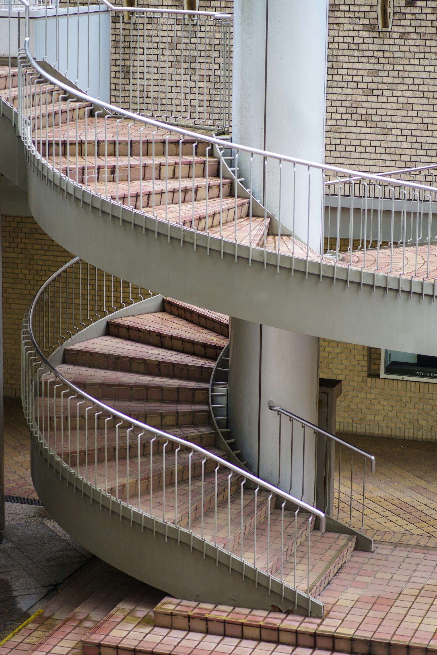 Gros plan d'un escalier en spirale avec des rampes blanches et un sol carrelé