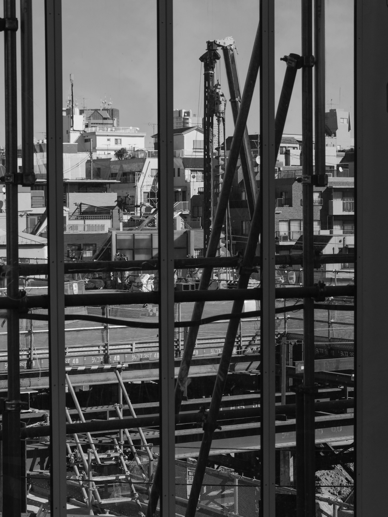Situs konstruksi terlihat melalui kaca bangunan dengan rangka baja