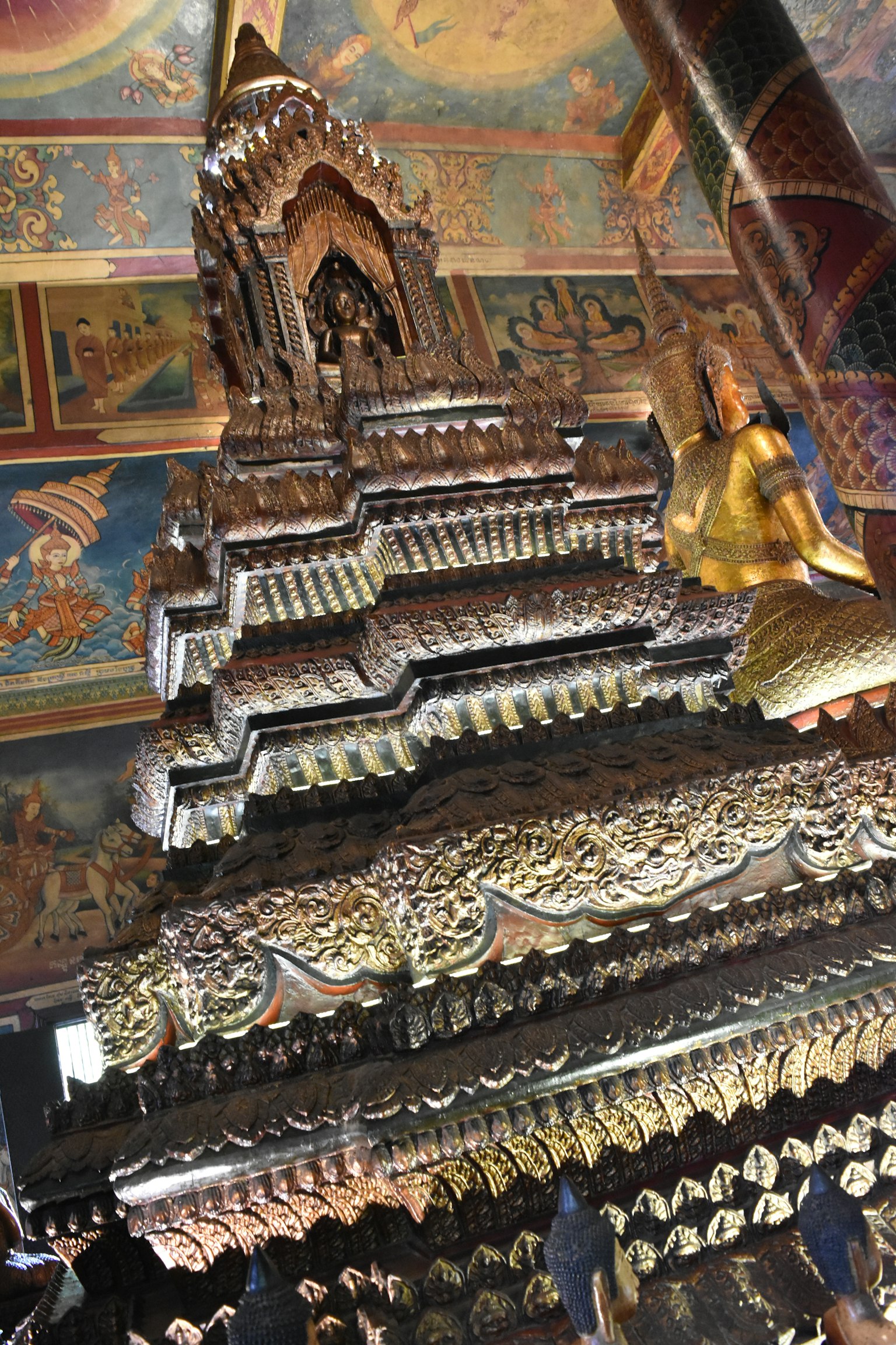 Tallados intrincados de una estructura de templo con una estatua dorada de Buda