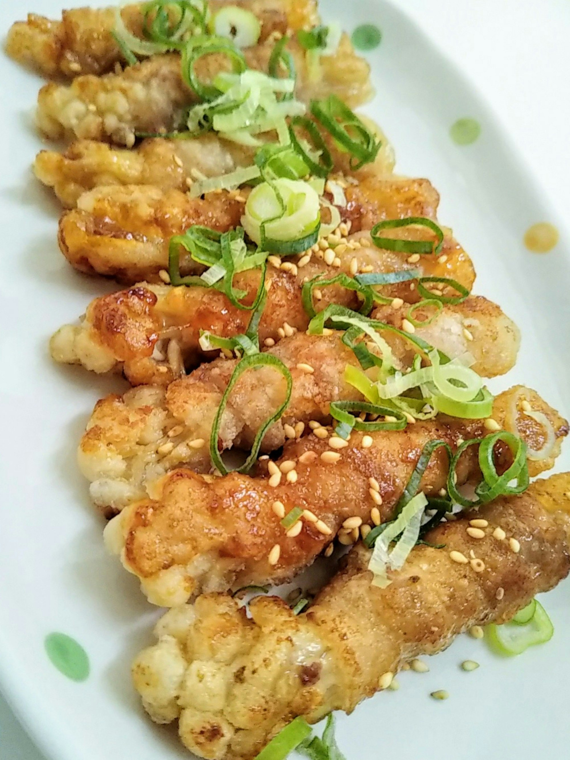 frittierte Reiskuchenstücke mit Frühlingszwiebel und Sesam