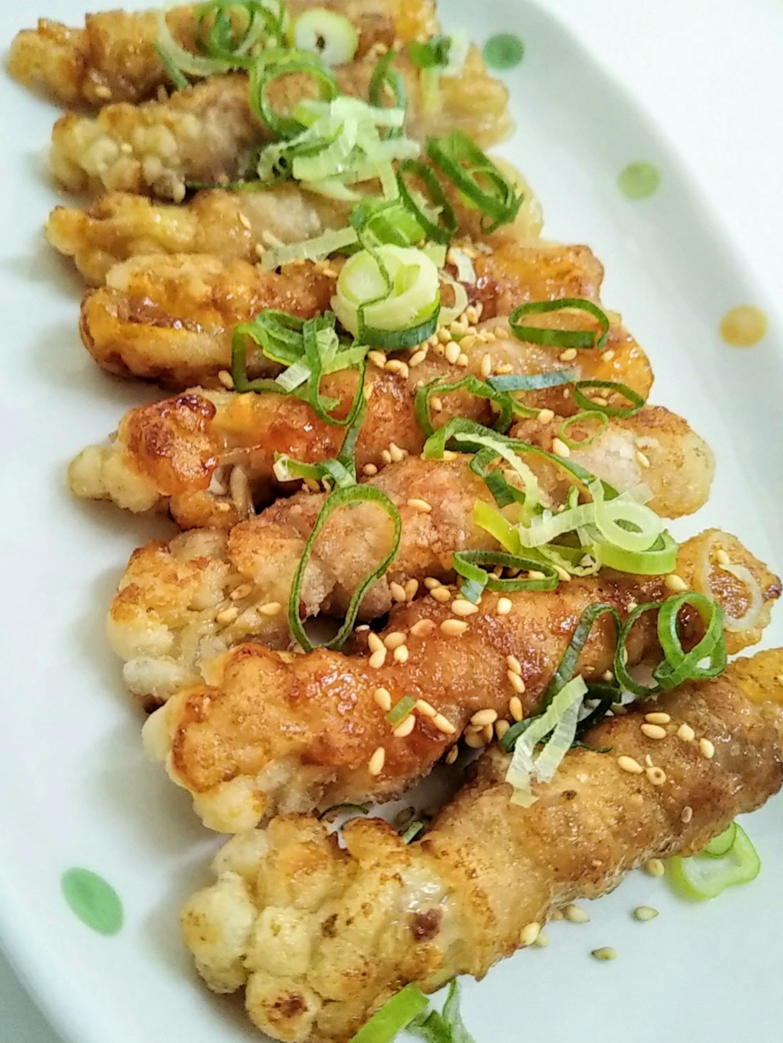 Đĩa thực phẩm chiên trang trí bằng hành lá và hạt mè