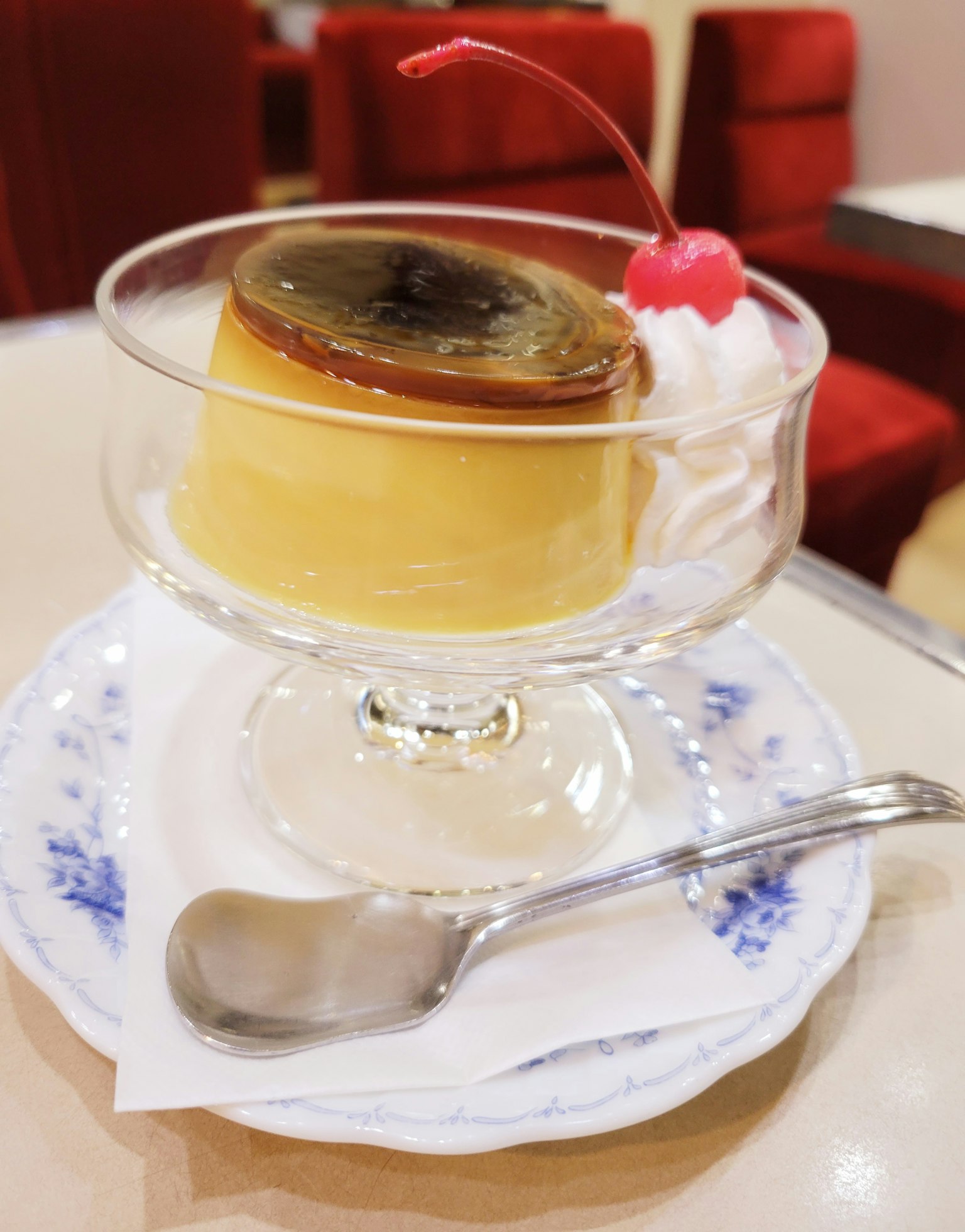Creamy dessert in a glass dish with a cherry on top