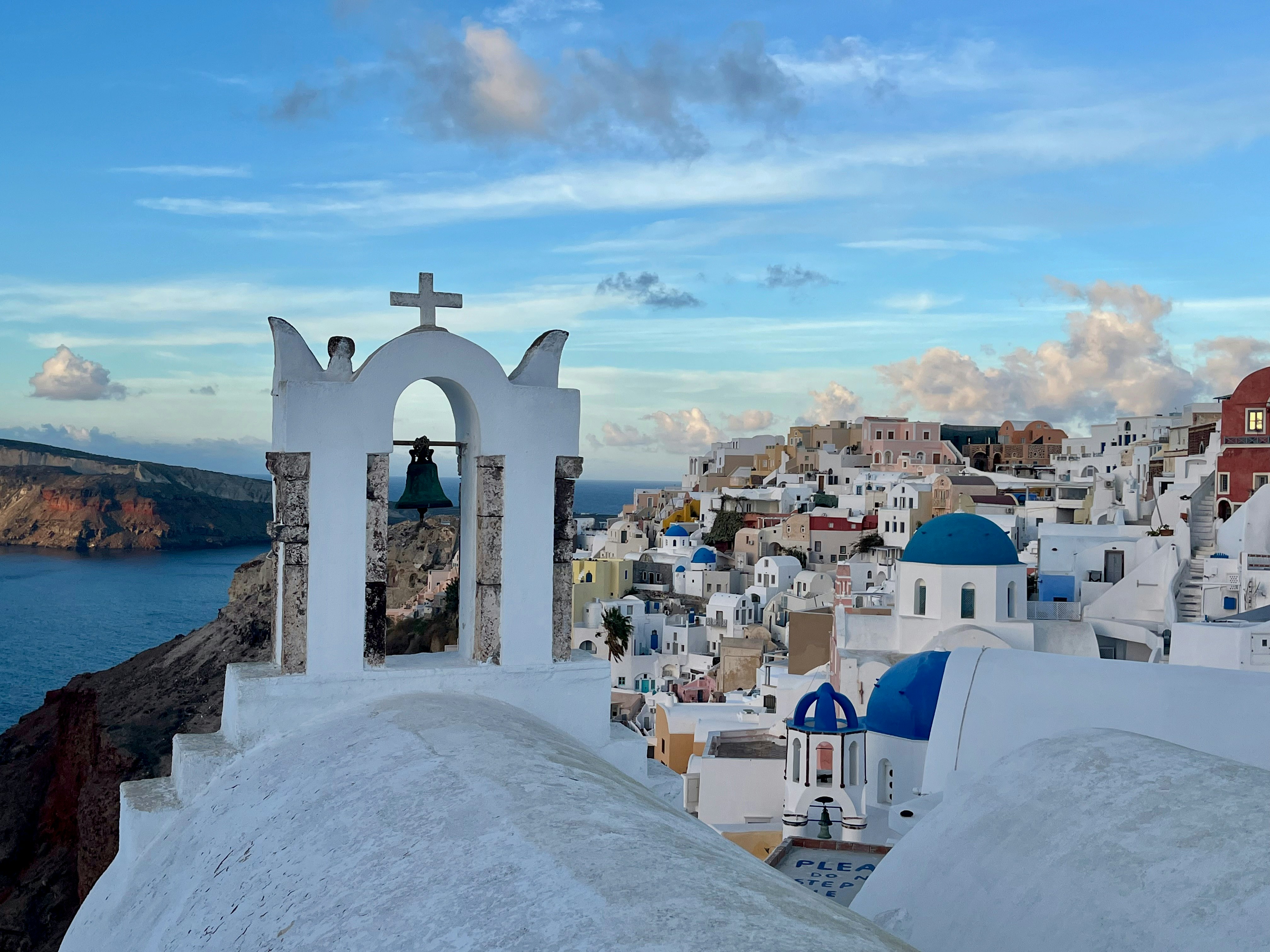 Toàn cảnh Oia ở Santorini với chuông nhà thờ màu trắng và các mái vòm màu xanh