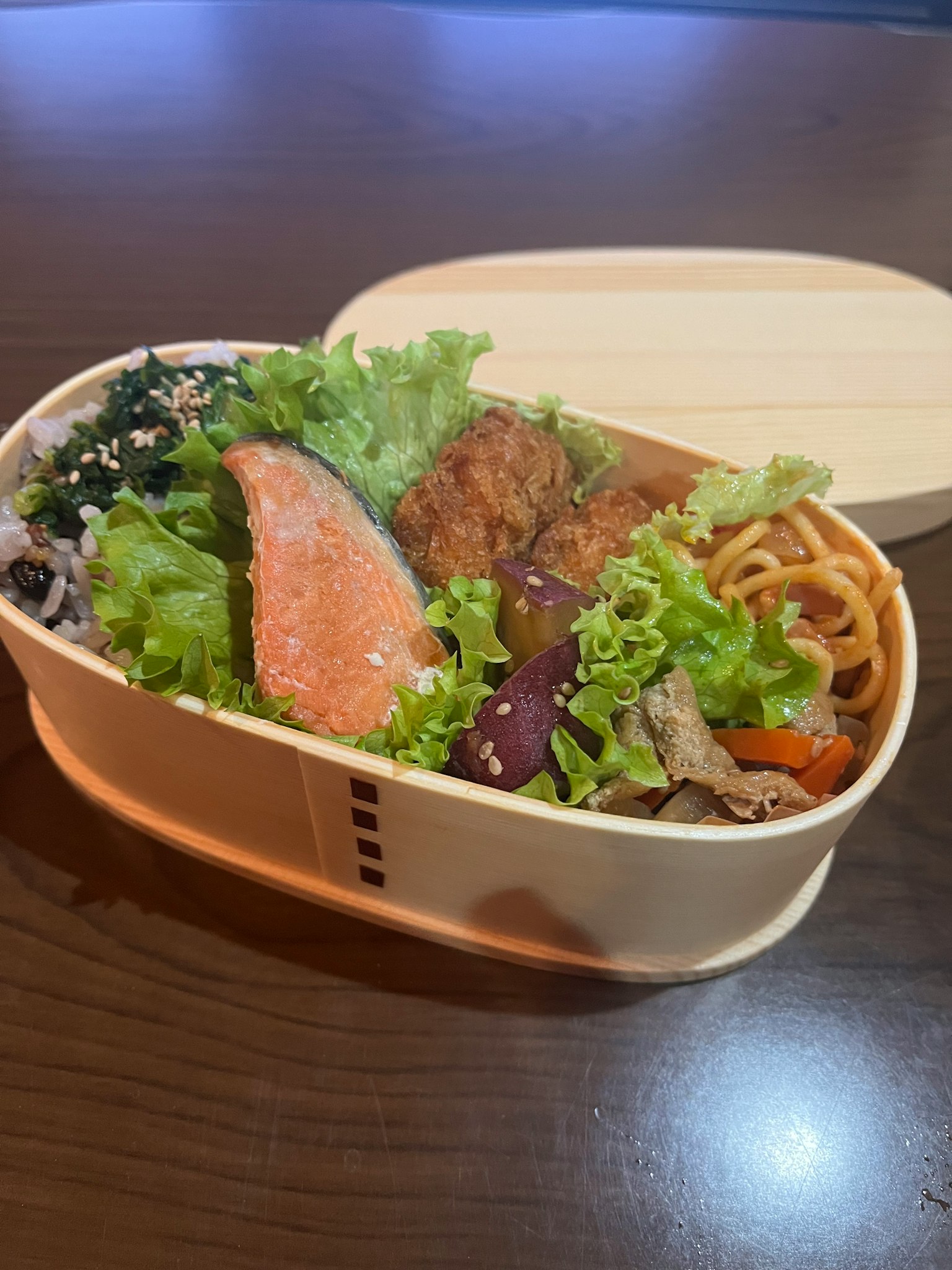 便当盒，里面有三文鱼、生菜和各种配菜