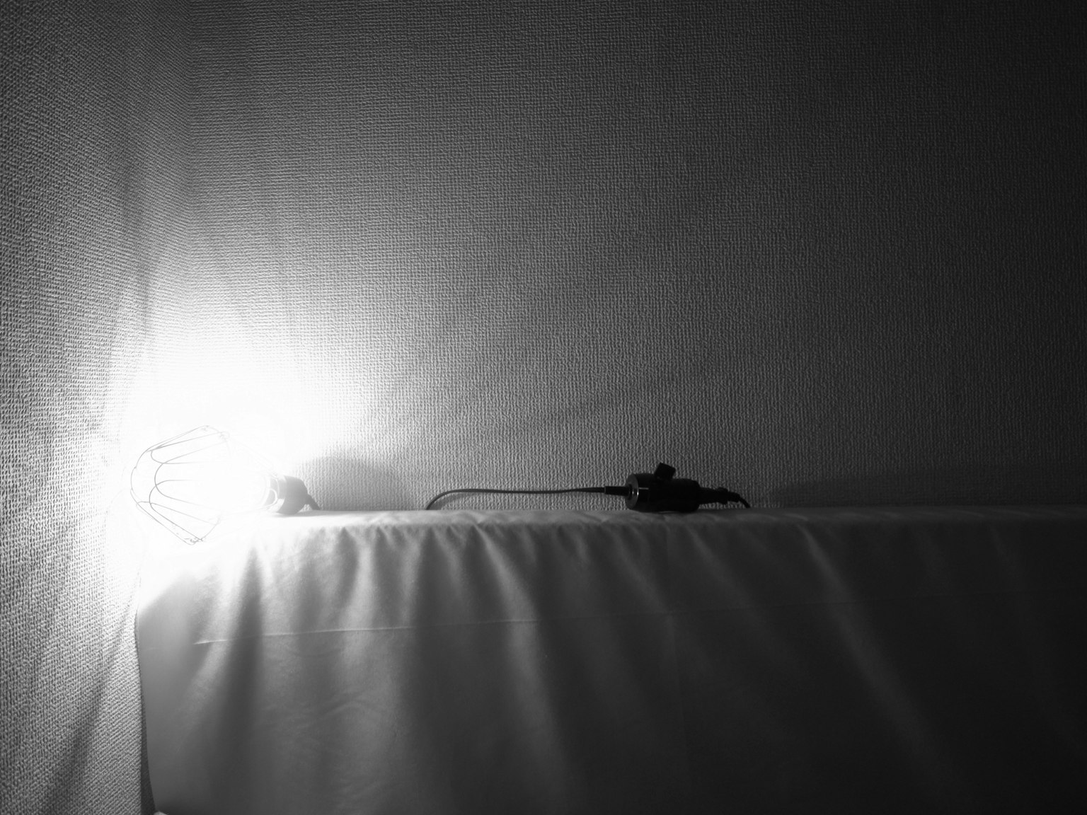 Ein Schwarz-Weiß-Bild, das einen schönen Kontrast zwischen Licht und Schatten mit einem Objekt auf einem Tisch zeigt