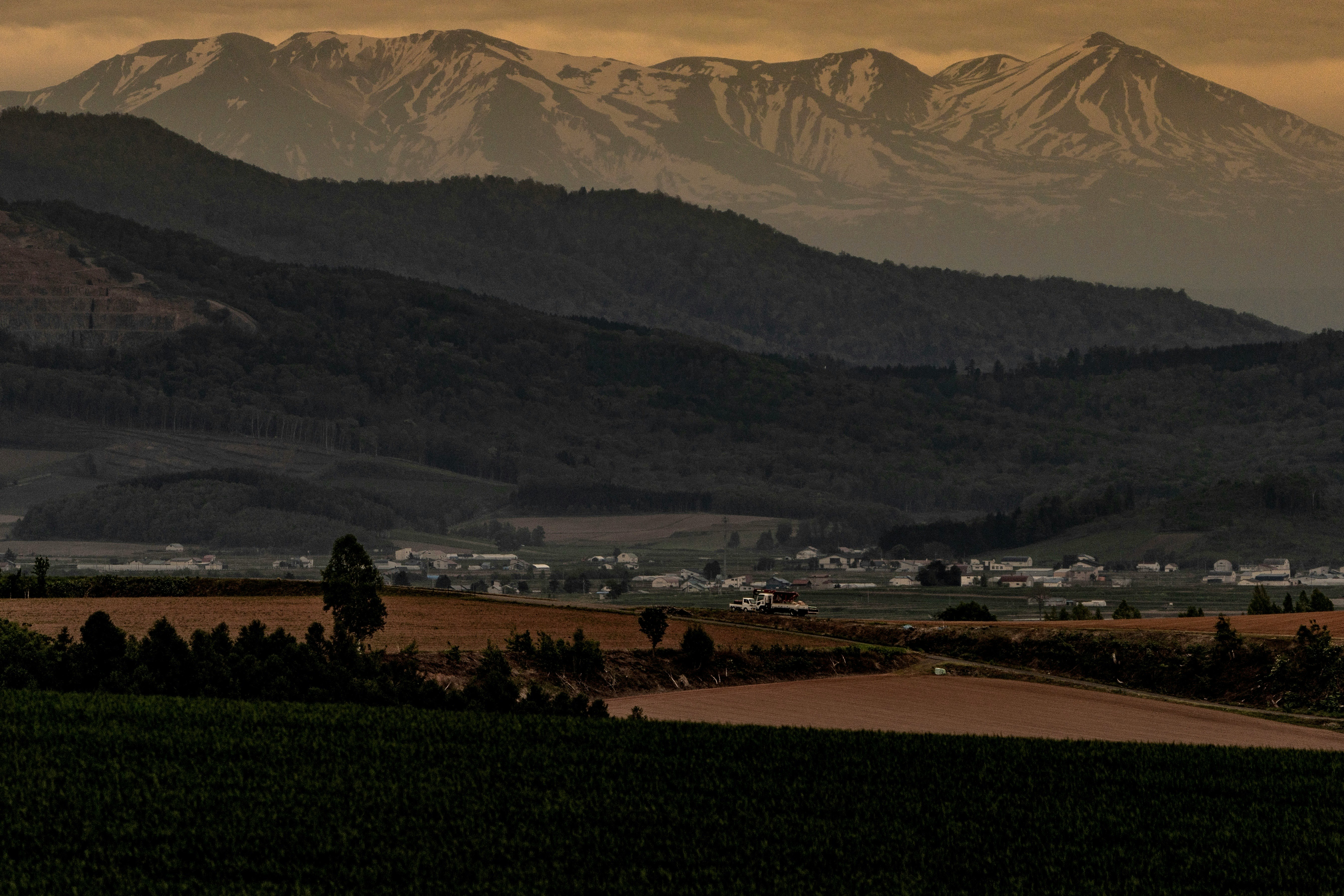 dusk mountain range over a rural farmland landscape