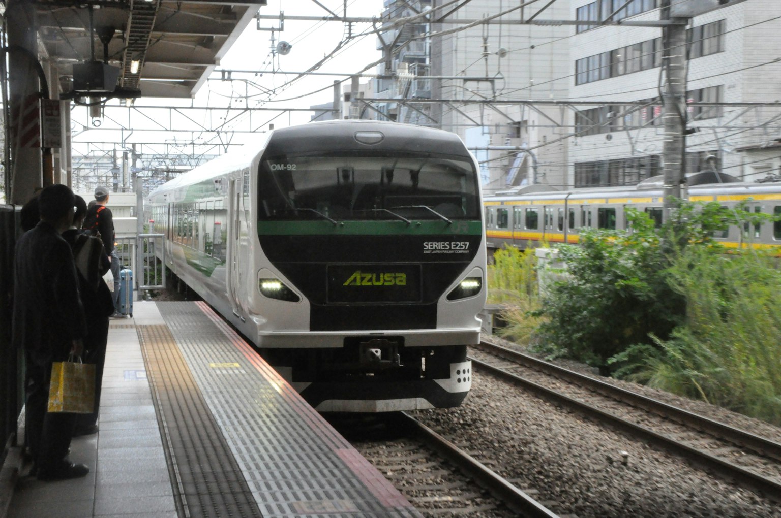 Treno moderno in arrivo a una stazione con edifici circostanti
