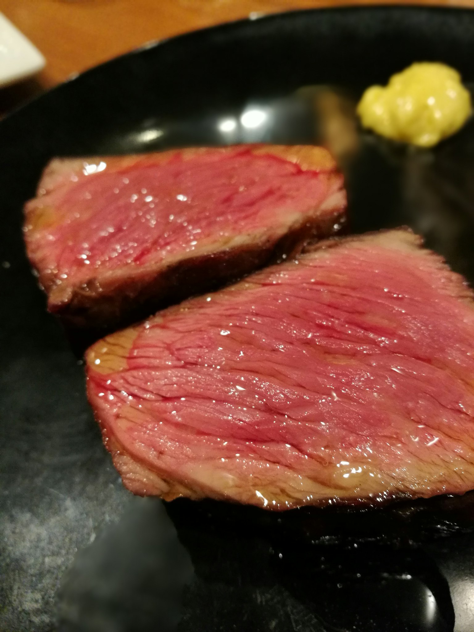 黑色盤子上的美麗和牛肉片和芥末