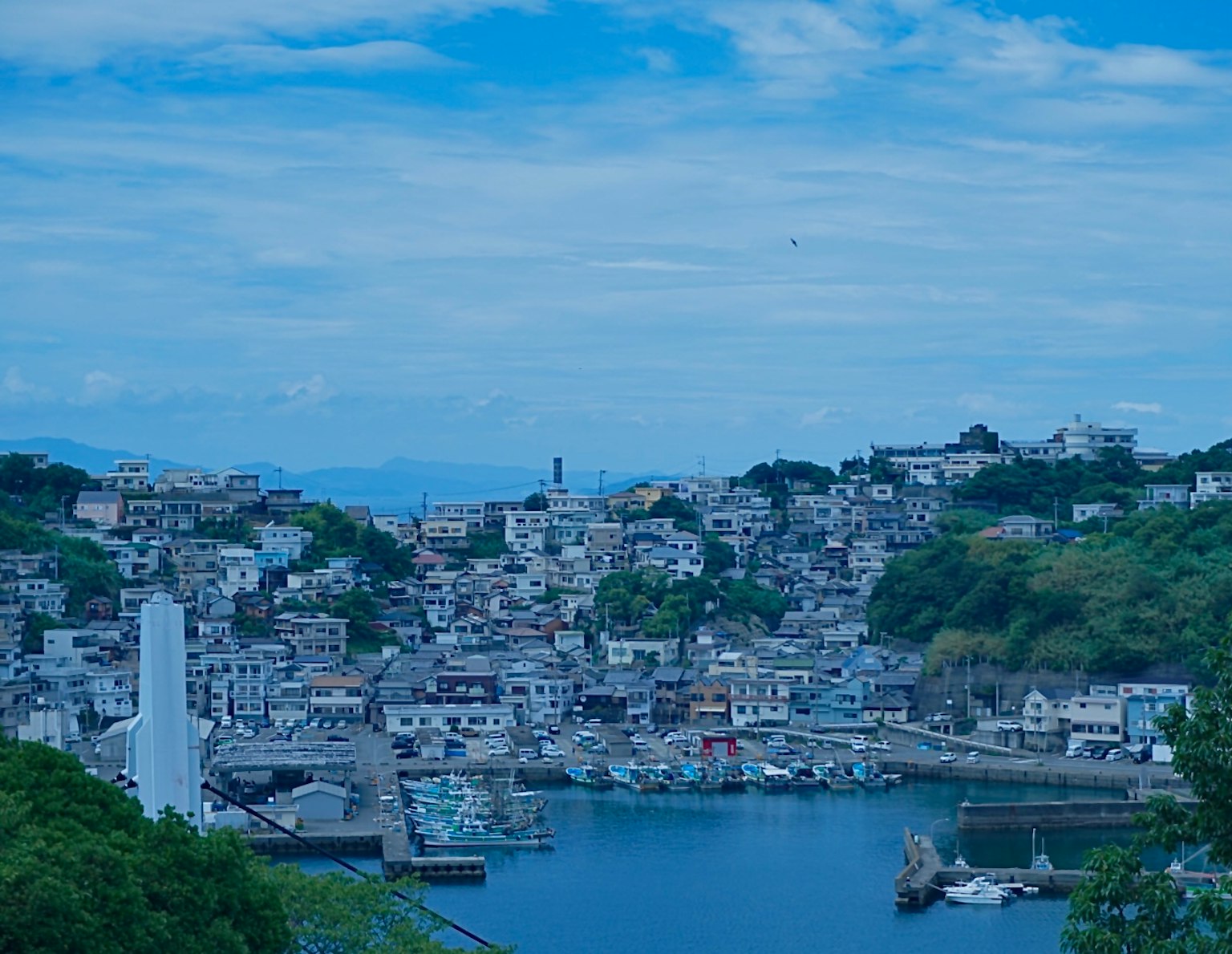 Vue pittoresque d'une ville côtière sous un ciel bleu avec des maisons regroupées et un port