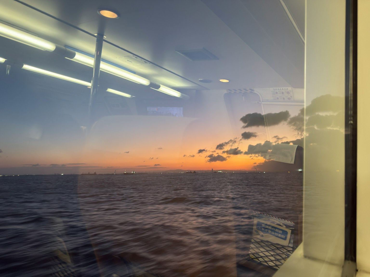 Vue du coucher de soleil et de l'océan à travers une fenêtre