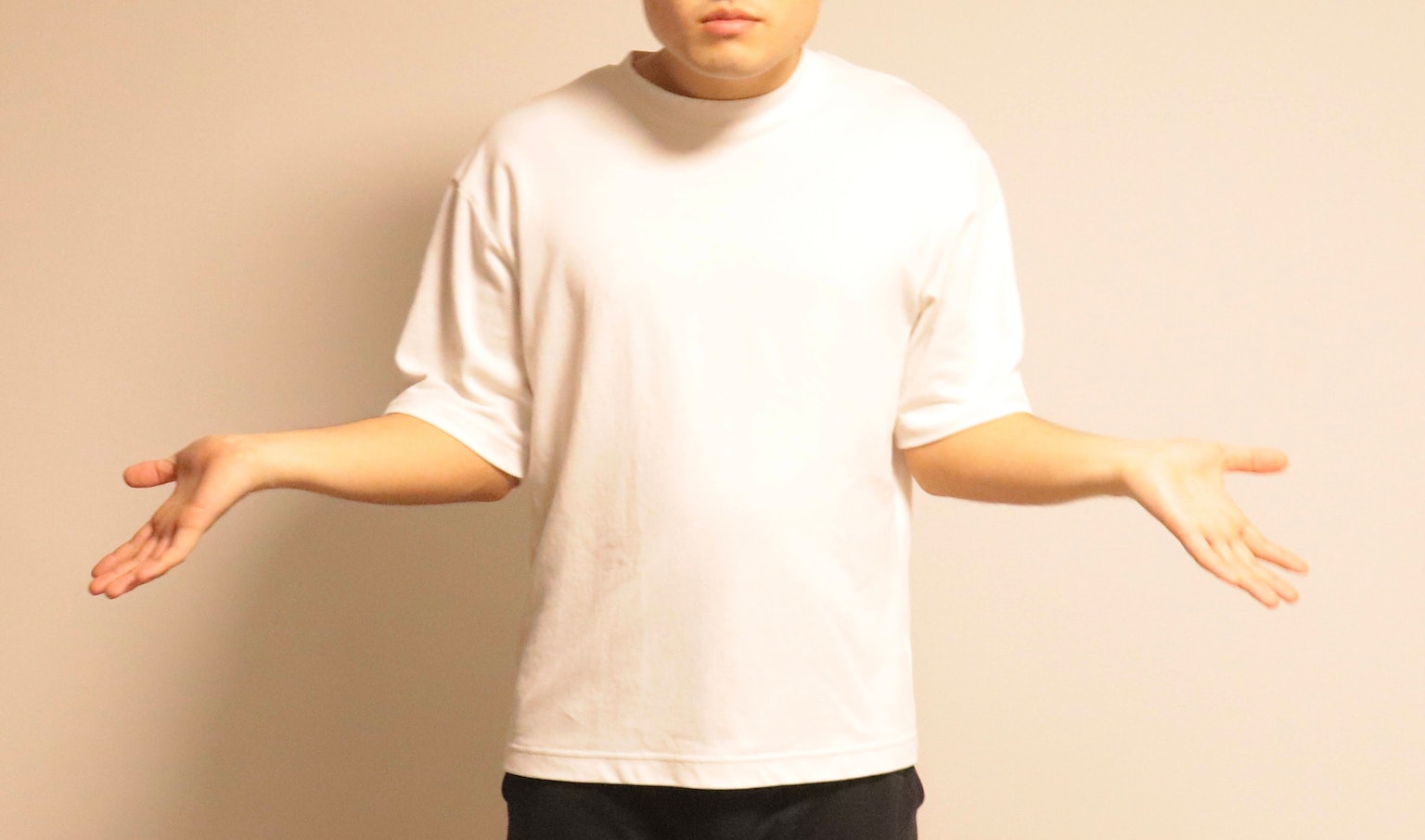 Homme en T-shirt blanc les bras écartés