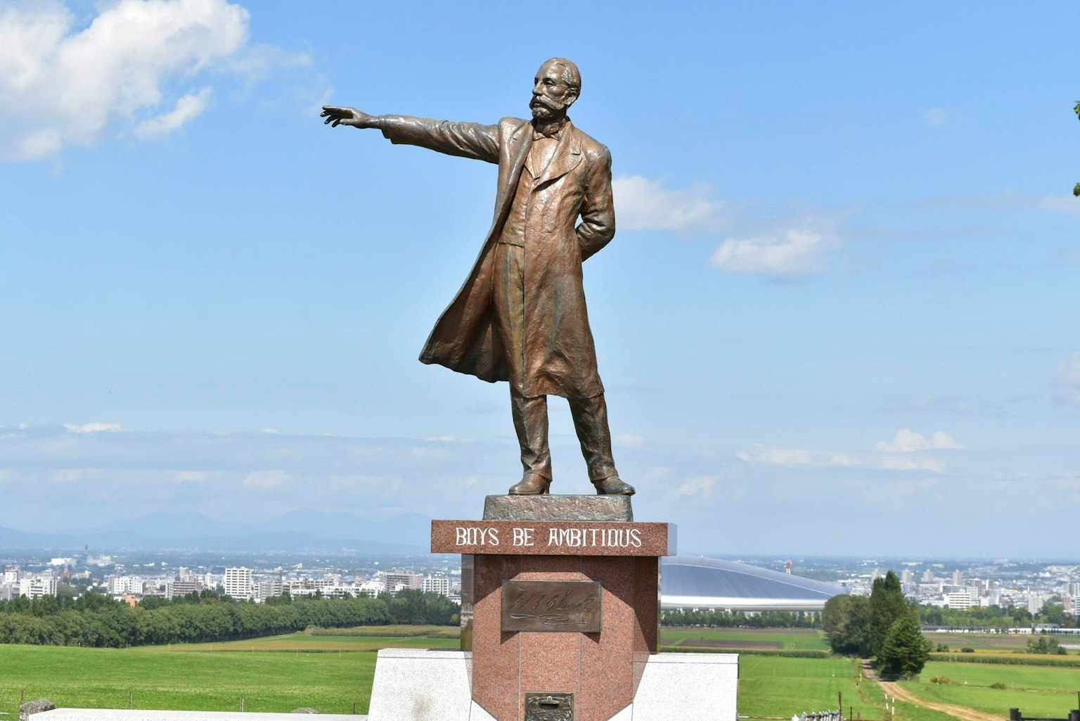 Statue en bronze de Lénine se tenant sous un ciel bleu pointant au loin