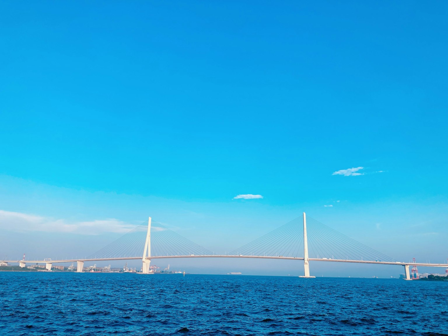 ทิวทัศน์ที่สวยงามของสะพานและทะเลใต้ท้องฟ้าสีฟ้า