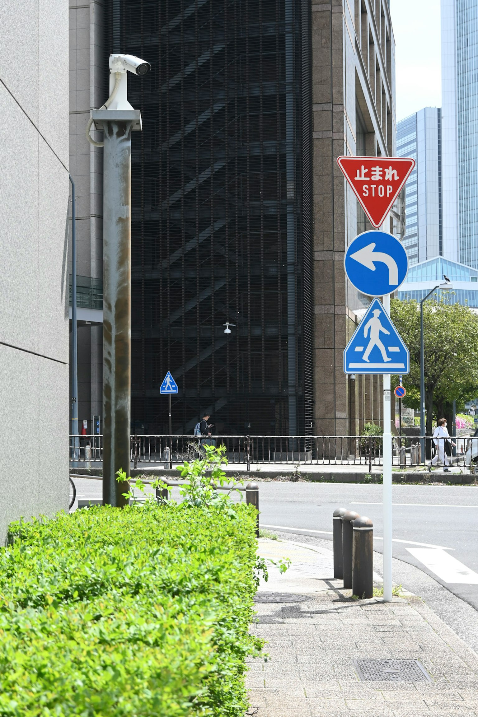 Señales de tráfico y setos verdes entre edificios