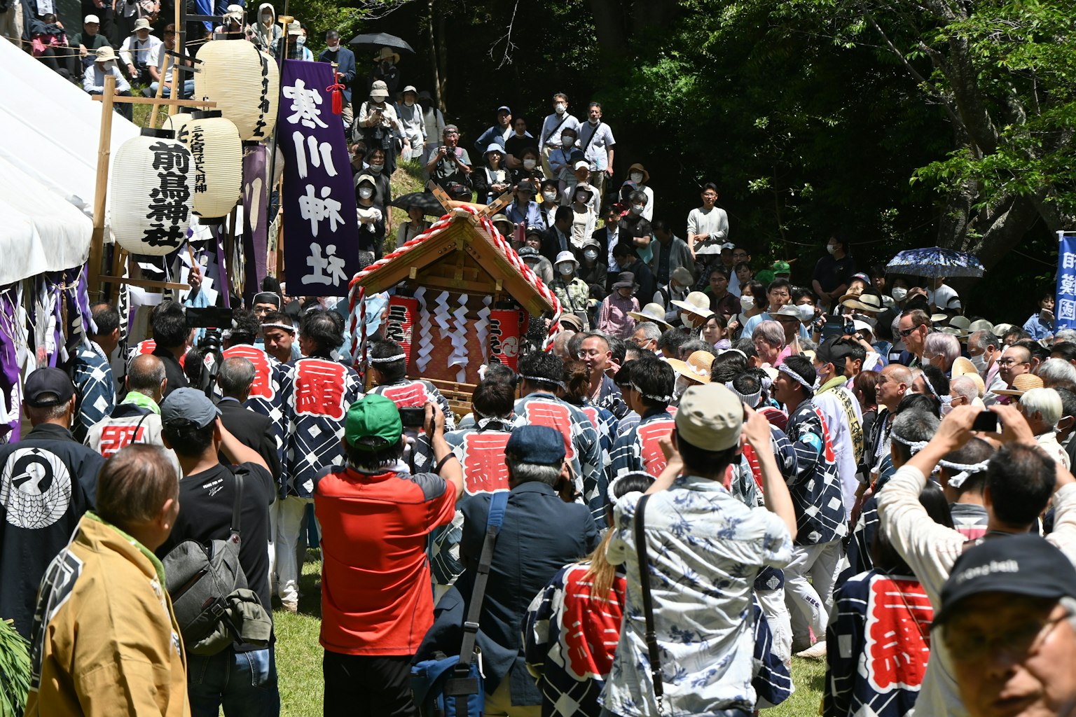 Des gens rassemblés autour d'un sanctuaire portable lors d'un défilé de festival