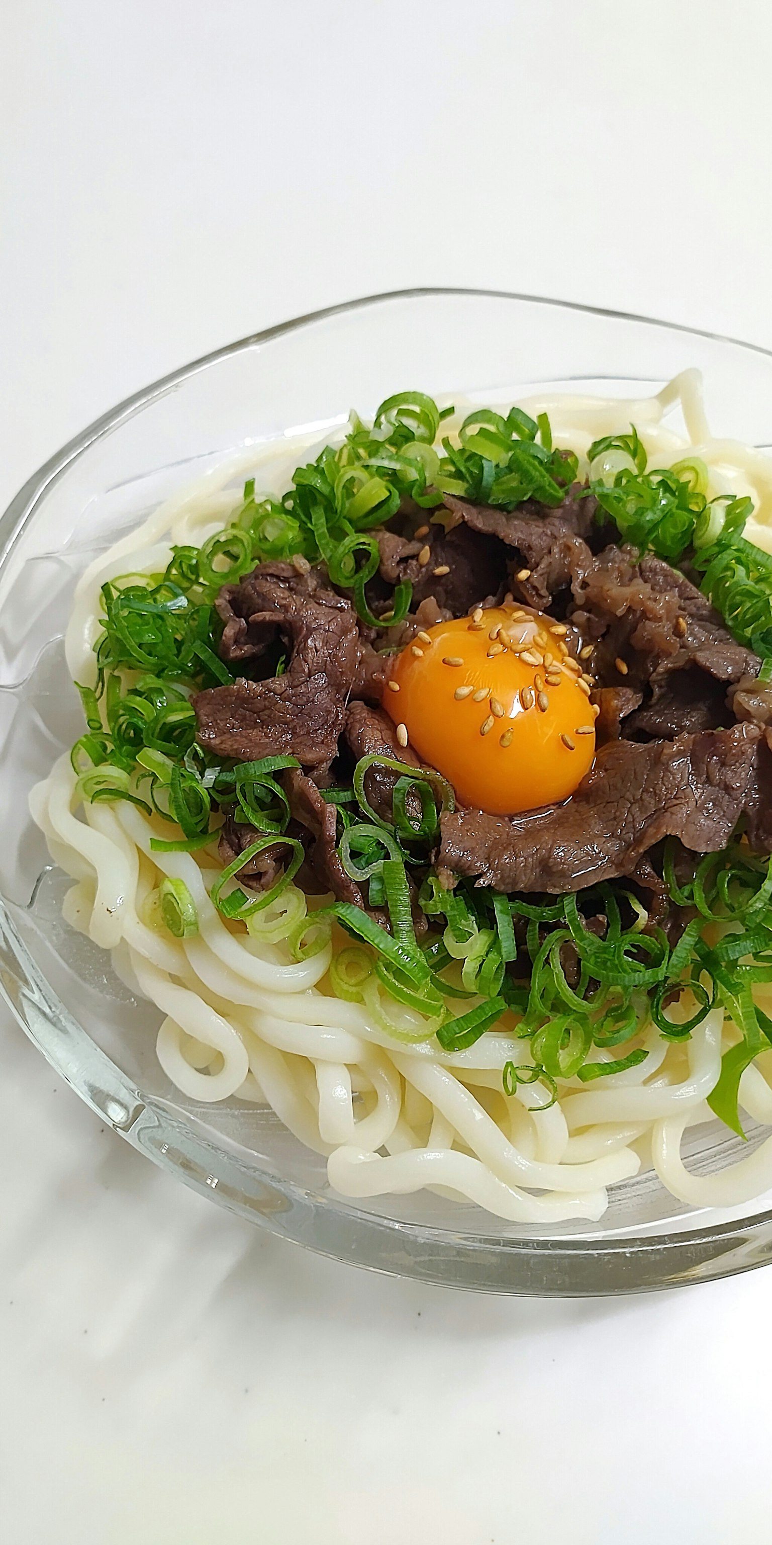 Gericht mit Udon-Nudeln, belegt mit Rindfleisch und Eigelb