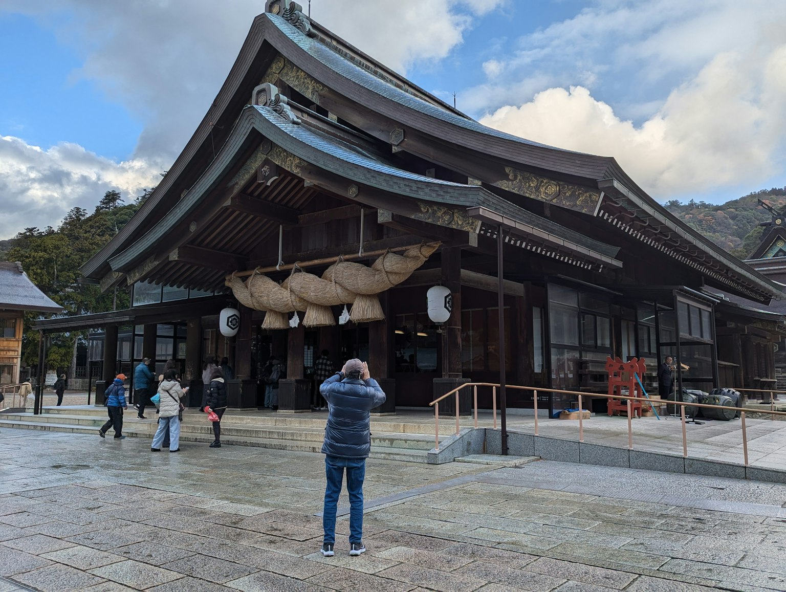 Traditional Japanese shrine building with visitors