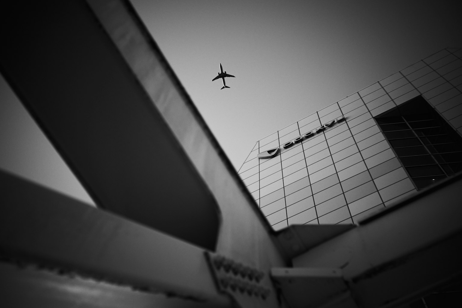 Contrast of a flying airplane and a modern building