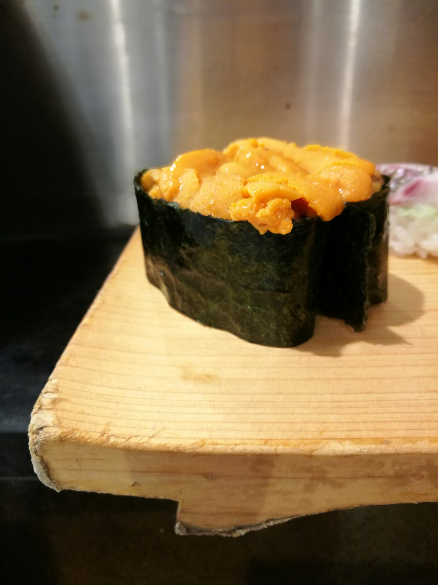 Sushi gunkan cubierto de erizo de mar en una tabla de madera