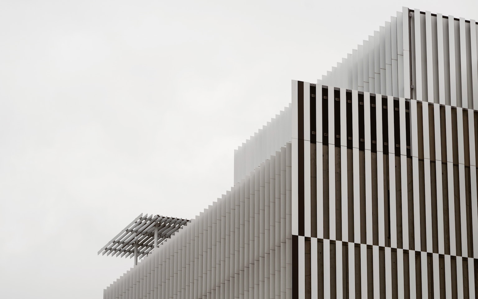 Bâtiment moderne avec un design rayé et un ciel gris