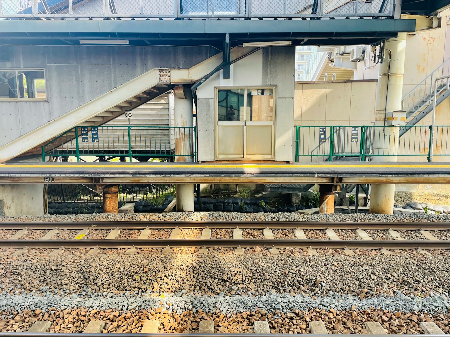 Vue d'une plateforme de gare avec des escaliers et une structure de bâtiment