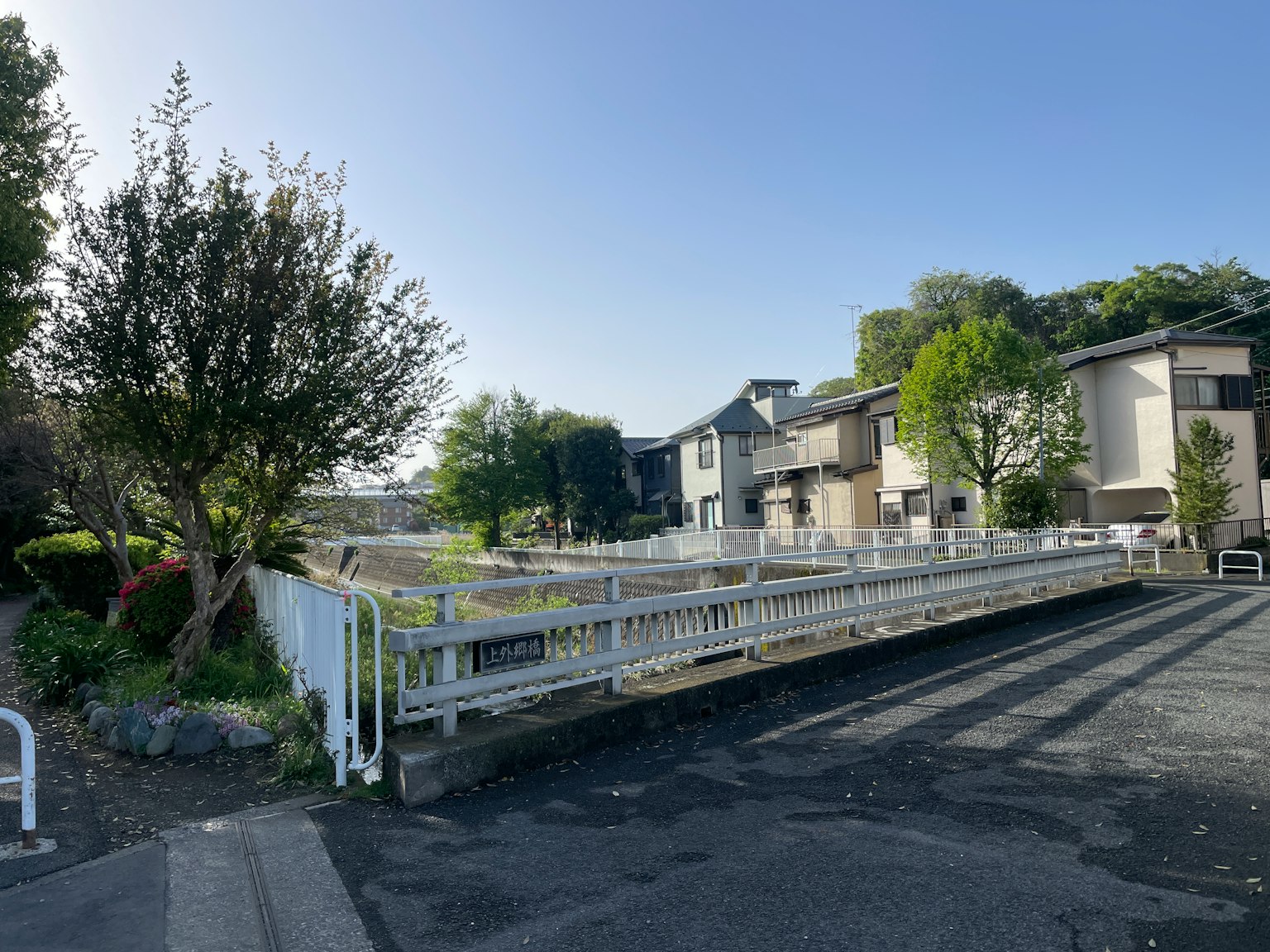 Vue d'un quartier résidentiel avec une clôture blanche et des arbres verts