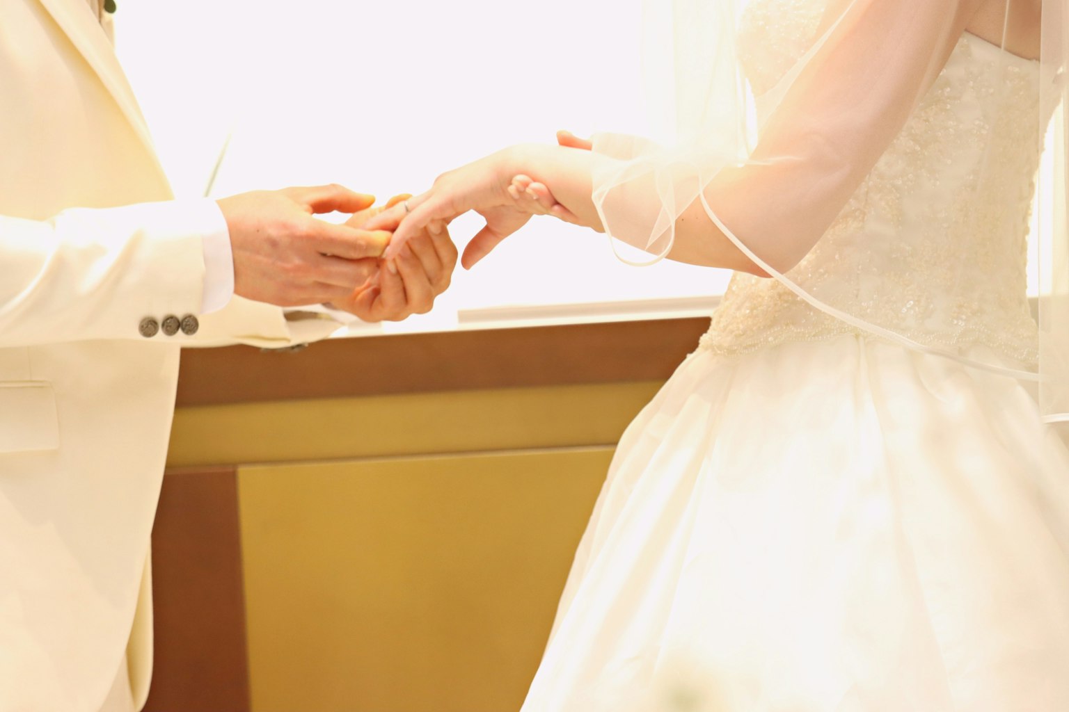 Hands of a bride and groom exchanging wedding rings