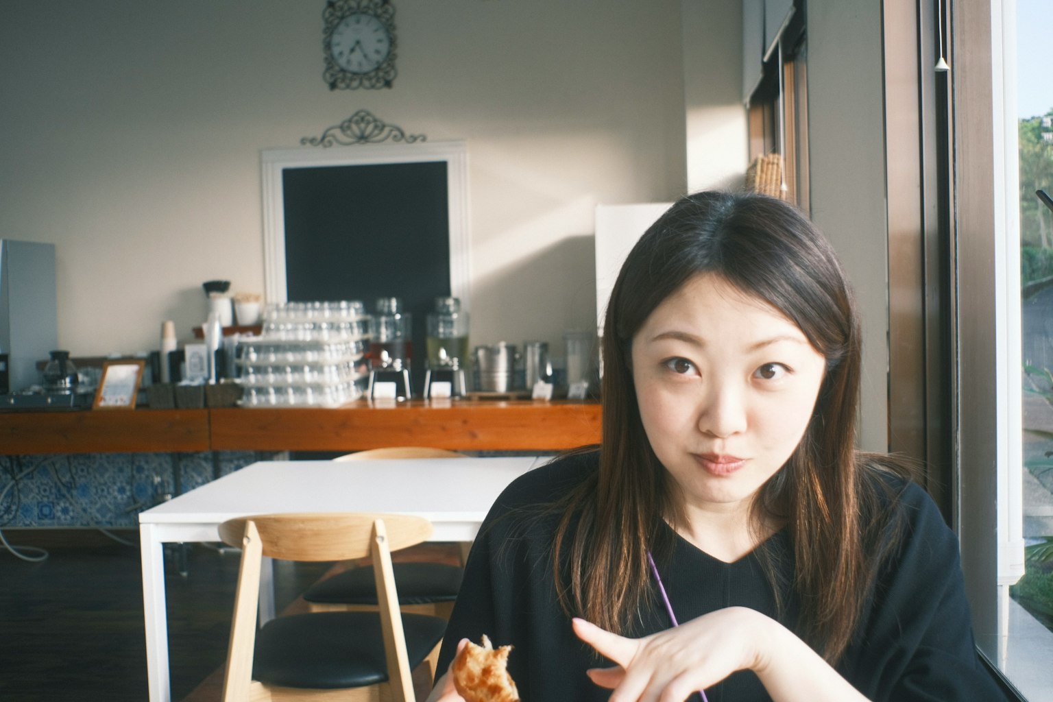 在咖啡館吃東西的女性肖像 背景有咖啡設備和桌子
