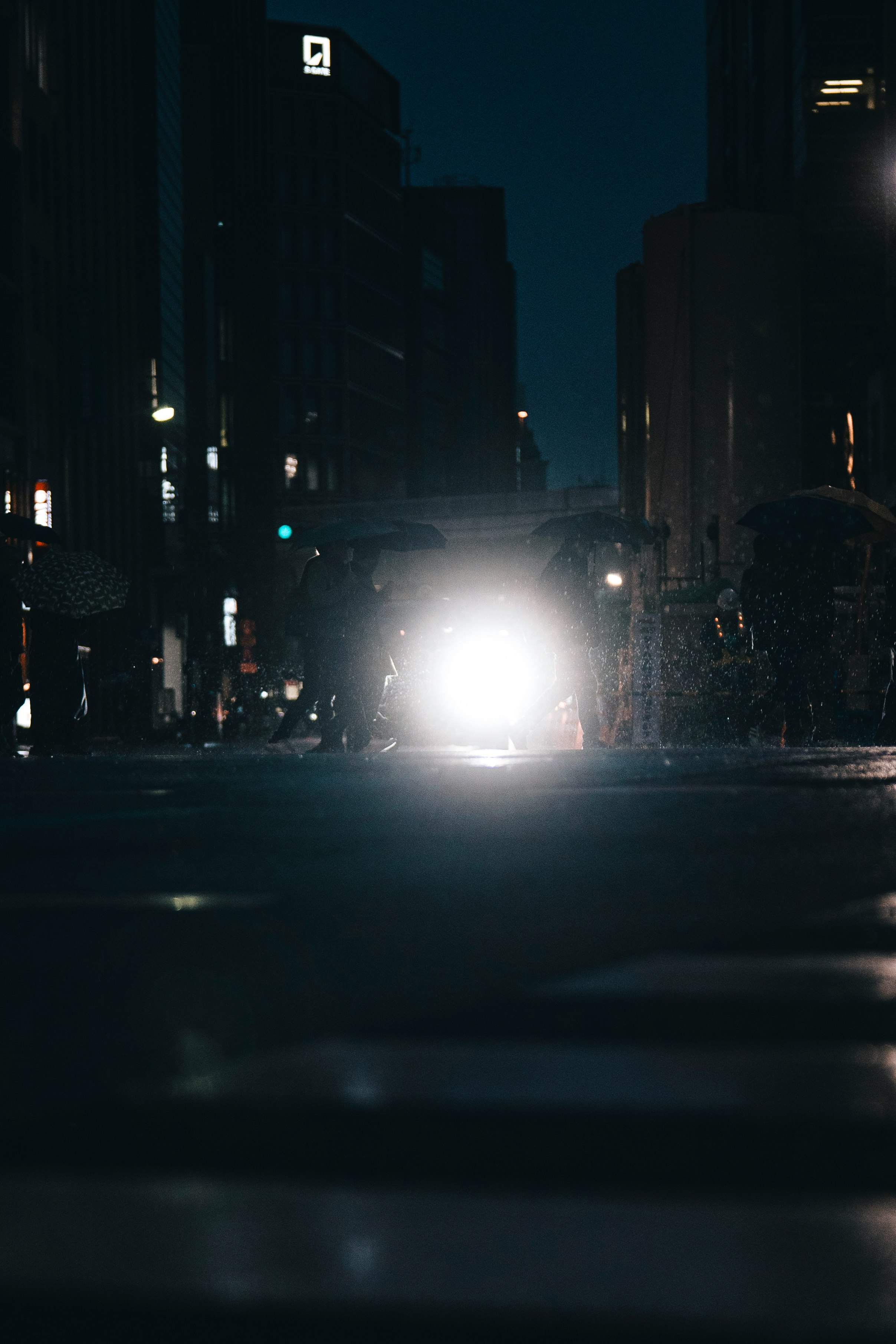 rue de nuit avec les phares lumineux d’une voiture